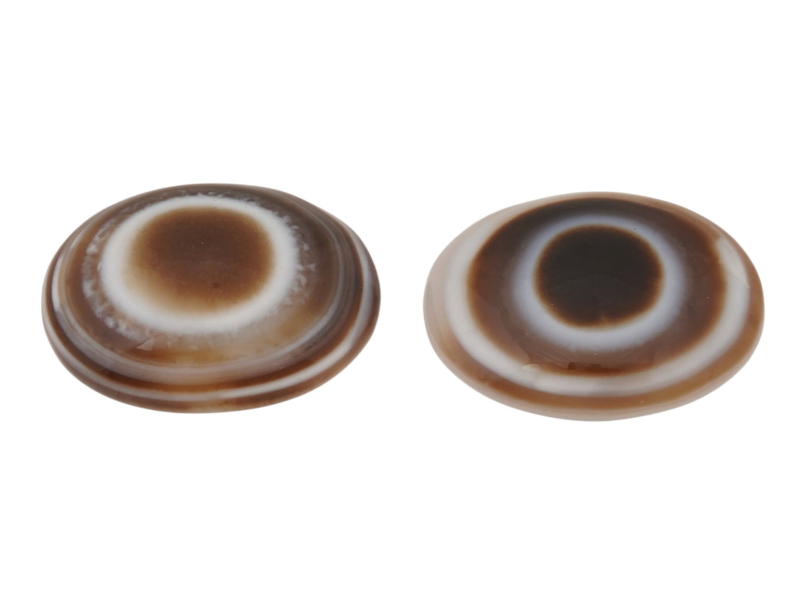 PAIR OF LARGE NATURAL BULLSEYE BANDED AGATE CABOCHON: A pair of large natural bullseye banded agate cabochons. The polished gemstones display a concentric eye pattern with alternating brown and white bands. Natural Gemstones And Jewelry Collectibles. THI