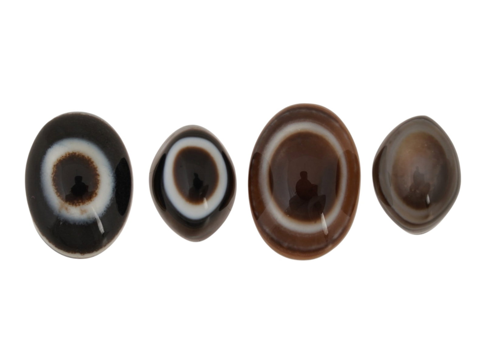 LOT OF NATURAL BULLSEYE BANDED AGATE CABOCHONS: A lot of four natural bullseye banded agate cabochons. The polished gemstones display a concentric eye pattern with alternating brown and white bands. Natural Gemstones And Jewelry Collectibles. THIS
