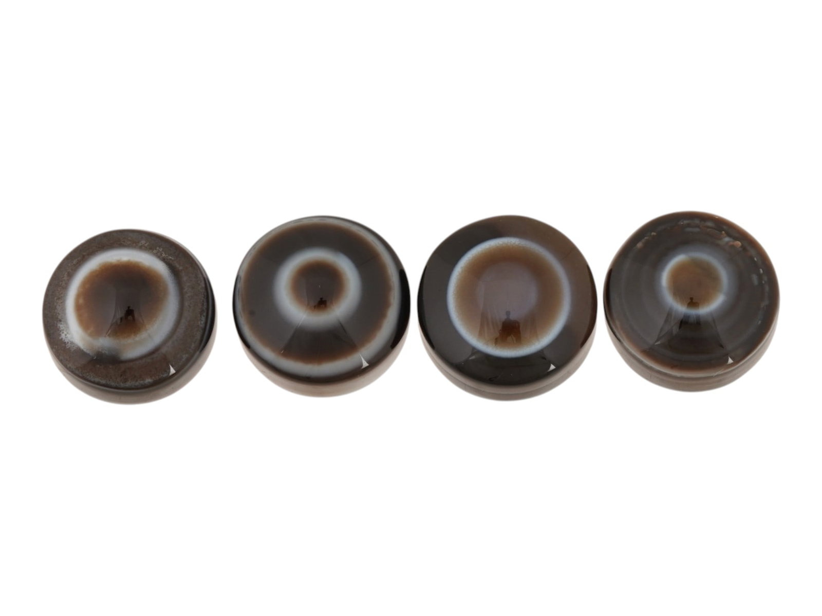 LOT OF NATURAL BULLSEYE BANDED AGATE CABOCHONS: A lot of four natural bullseye banded agate cabochons. The polished gemstones display a concentric eye pattern with alternating brown and white bands. Natural Gemstones And Jewelry Collectibles. THIS
