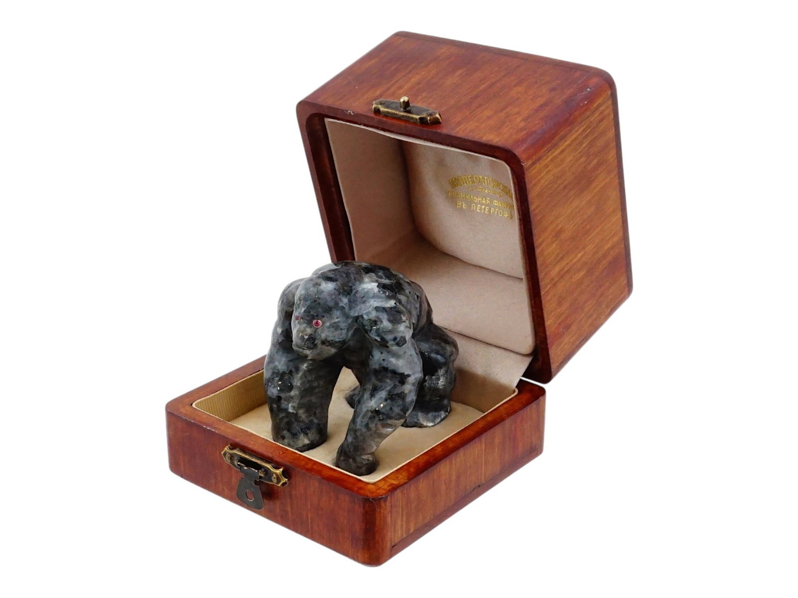 RUSSIAN LABRADORITE FIGURE OF GORILLA W GEMSTONE EYES: A Russian carved gemstone sculpture depicting a gorilla in a knuckle-walking pose. The figure is carved from labradorite with natural iridescent flashes and inset red gemstone eyes in gold fittings. I