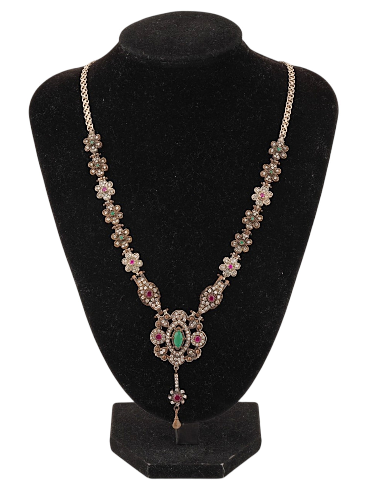 AMERICAN FLORAL DESIGN STERLING SILVER NECKLACE: An American sterling silver necklace featuring a central openwork pendant embellished with a green cabochon and red accent stones, suspended from a sequence of floral shaped links and a textured popco