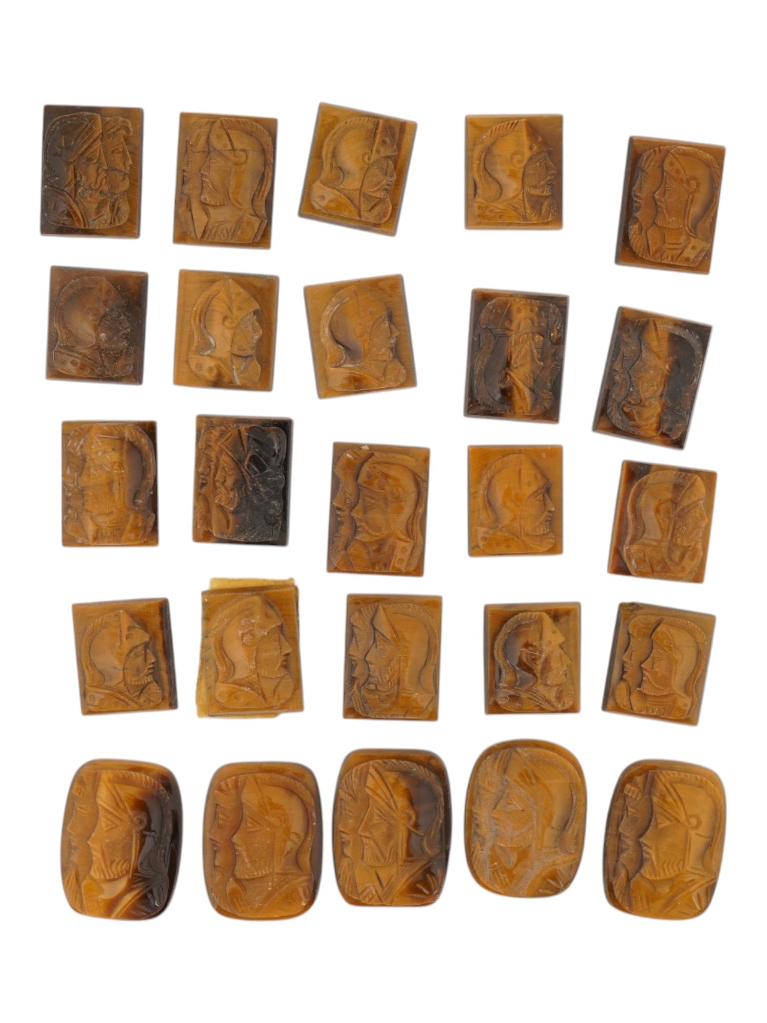 COLLECTION OF PORTRAIT CARVED TIGERS EYE CAMEOS: A collection of hand carved tigers eye cameos. A total of 25 items. Each piece features a knight profile portrait rendered in high relief. Rectangular shape. Collectible Jewelry And Glyptic Art, Sculp