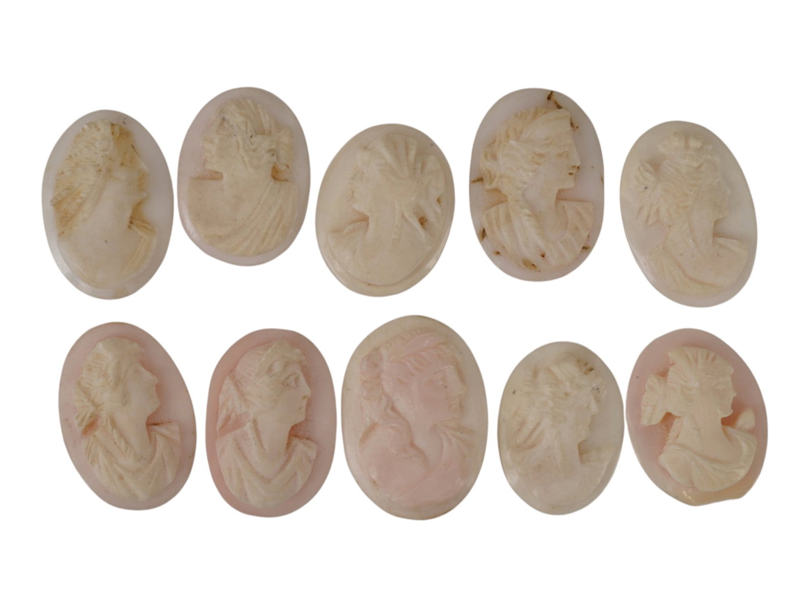 COLLECTION OF HAND CARVED CORAL CAMEO MEDALLIONS: A collection of vintage hand carved cameo medallions. A total of 10 items. Each piece is crafted from coral featuring a female portrait in the Victorian and Roman manners rendered in high relief. The 