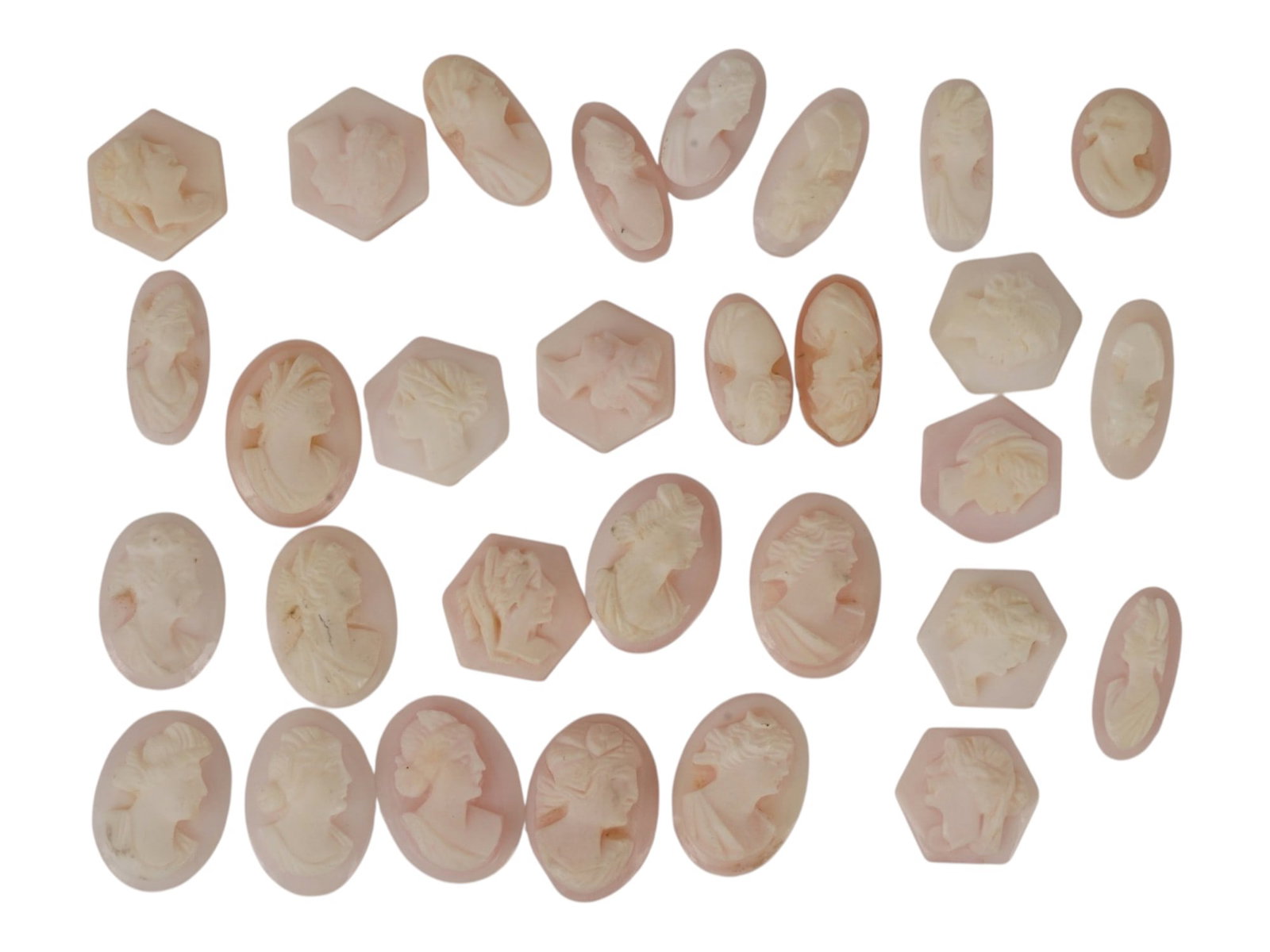 COLLECTION OF HAND CARVED CORAL CAMEO MEDALLIONS: A collection of vintage hand carved cameo medallions. A total of 30 items. Each piece is crafted from coral featuring a female portrait in the Victorian and Roman manners rendered in high relief. The 