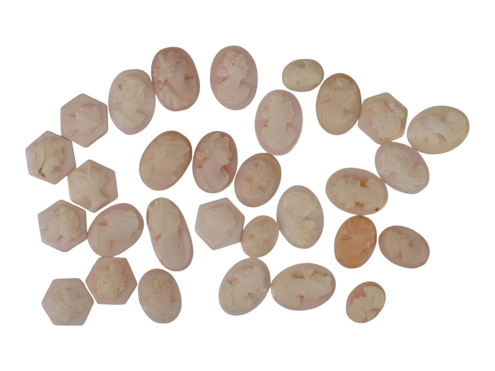COLLECTION OF VINTAGE HAND CARVED CONCH SHELL CAMEOS: A collection of vintage hand-carved conch shell cameos in mixed geometric shapes: mostly ovals, with hexagons and a few shield-form pieces. All feature classical female portrait profiles, facing both 