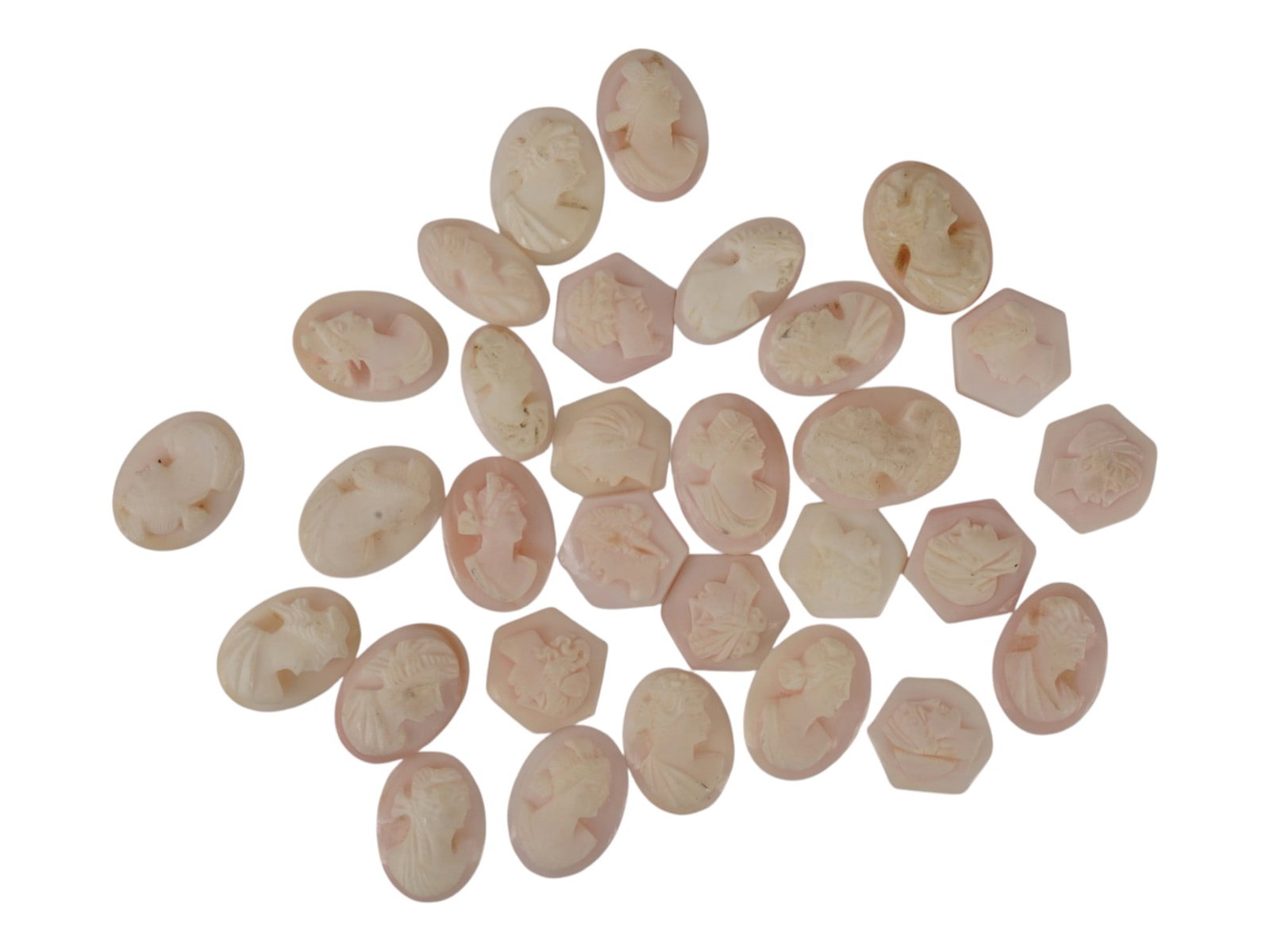 COLLECTION OF VINTAGE HAND CARVED CONCH SHELL CAMEOS: A collection of vintage hand-carved conch shell cameos in mixed geometric shapes: mostly ovals, with hexagons and a few shield-form pieces. All feature classical female portrait profiles, facing both 