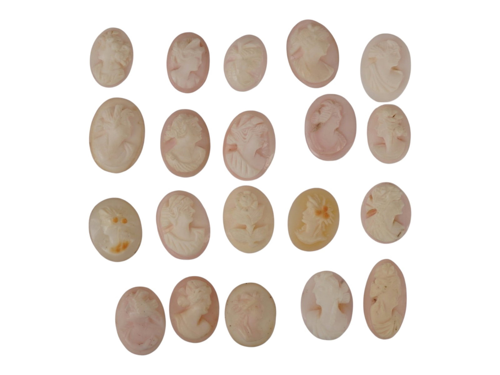 LOT OF FEMALE PORTRAIT CARVED PINK CORAL CAMEOS: A lot of 20 hand carved pink coral cameos. Each piece depicts a female profile portrait or flower rendered in high relief. Oval shape. Collectible Jewelry And Glyptic Art, Sculpture. THIS LOT IS ELIGI