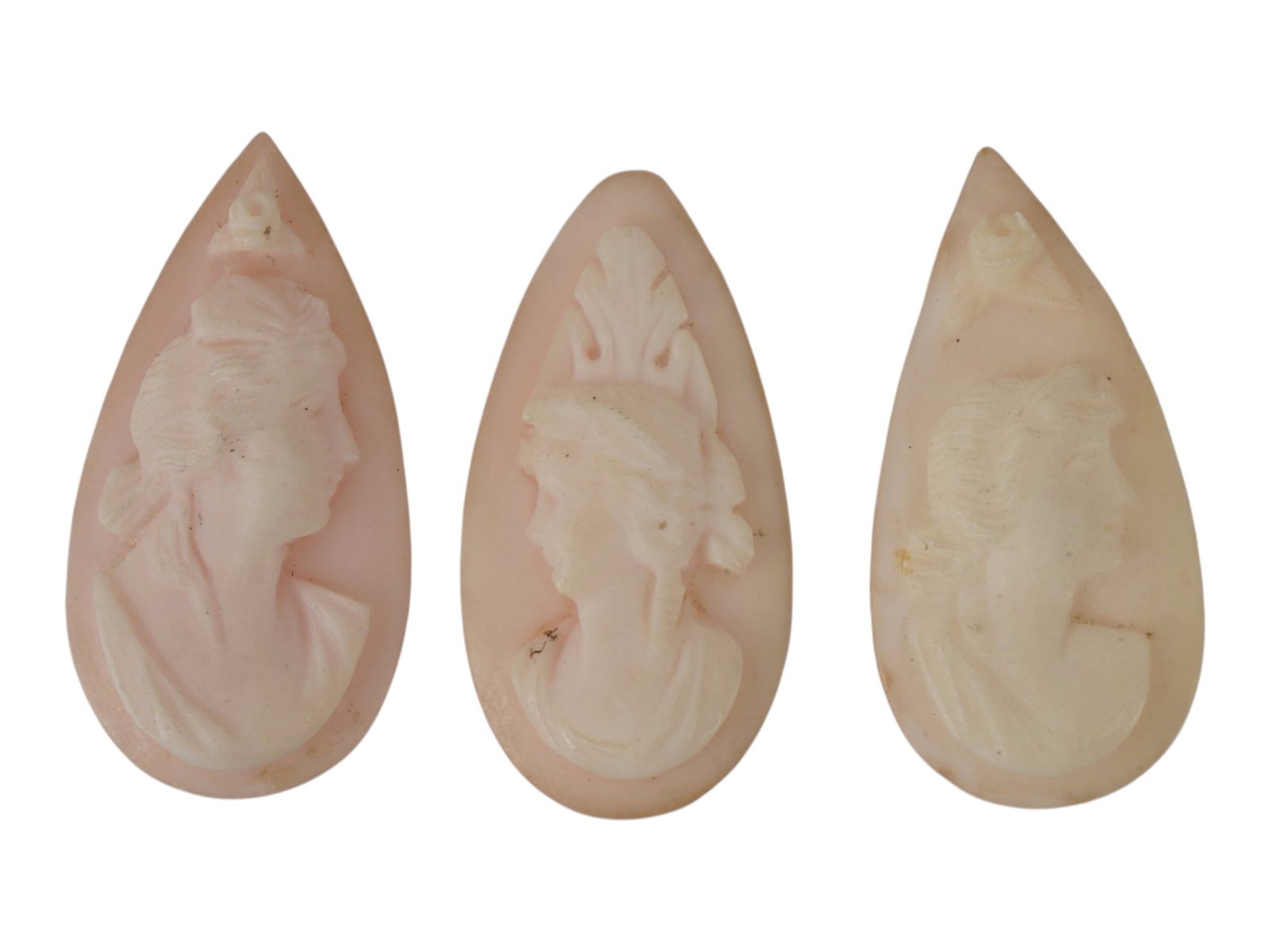 LOT OF FEMALE PORTRAIT CARVED PINK CORAL CAMEOS: A lot of three hand carved pink coral cameos. Each piece depicts a female profile portrait rendered in high relief. Drop shape. Collectible Jewelry And Glyptic Art, Sculpture. THIS LOT IS ELIGIBLE FOR
