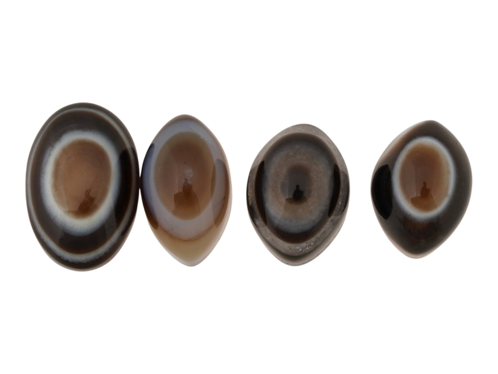 NATURAL BULLSEYE BANDED AGATE CABOCHONS: A lot of four natural Eye banded agate cabochons. The polished gemstones display a concentric eye pattern with alternating brown and white bands. Natural Gemstones And Jewelry Collectibles. THIS LOT I
