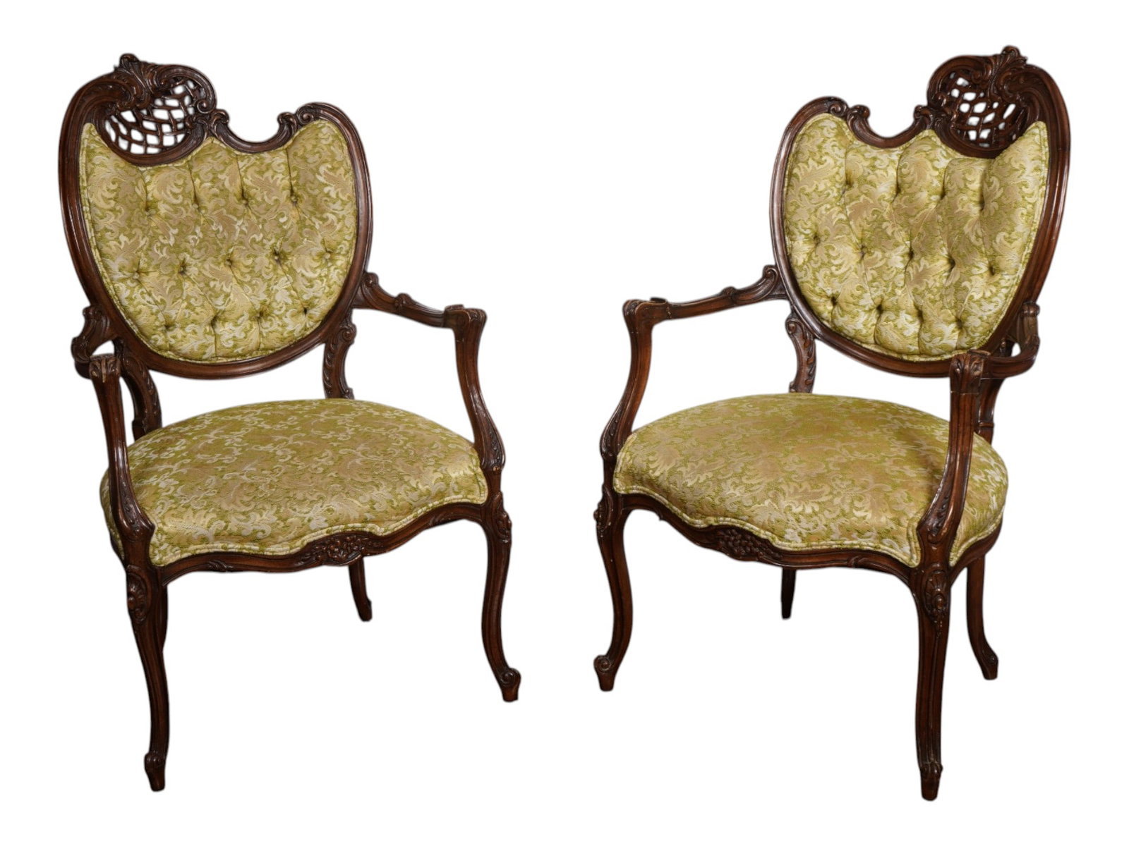 PAIR OF ANTIQUE ROCOCO REVIVAL UPHOLSTERED ARMCHAIRS: A pair of antique 19th-century Victorian armchairs. Rococo Revival style. Crafted from grained dark walnut, each chair features a balloon back crowned with an intricately carved crest incorporating an