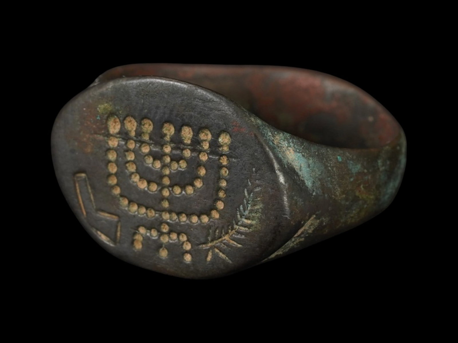ANCIENT ROMAN EMPIRE BRONZE MENORAH SIGNET RING: An Ancient Roman bronze signet ring. Imperial Rome era, ca. 100 to 300 AD. The crown is etched with a menorah and palm leaf image. Collectible Archaeological Finds And Relics, Jewelry, Judaica. THIS L