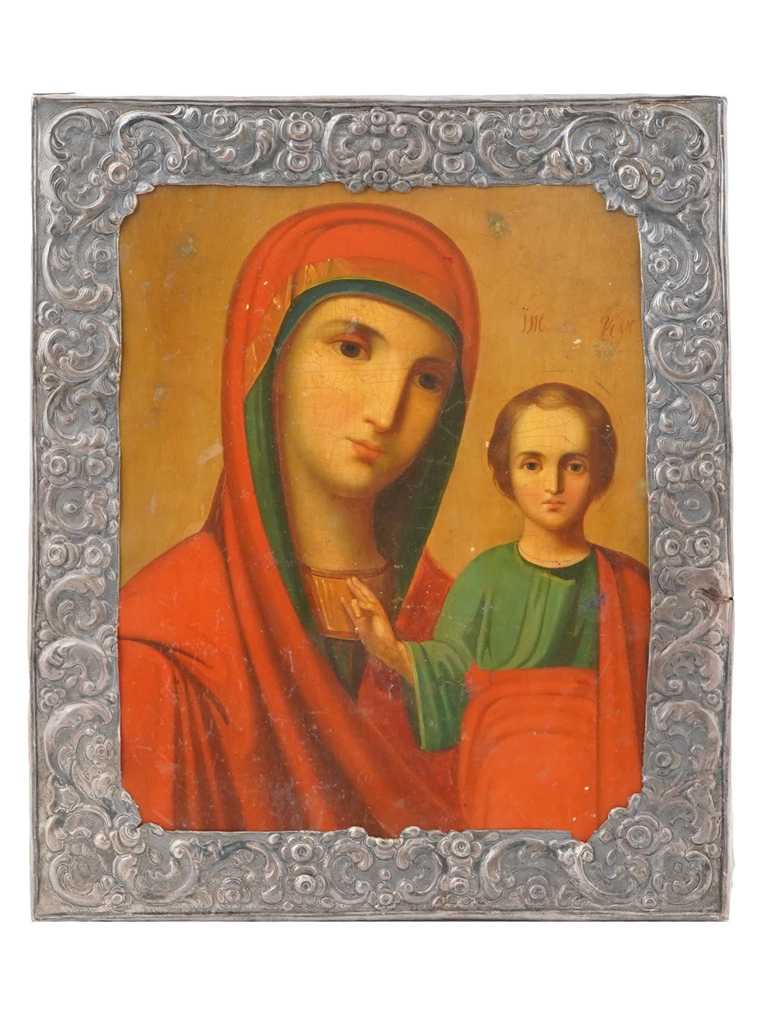 ANTIQUE RUSSIAN ICON KAZAN MOTHER OF GOD IN SILVER OKLAD: An antique 19th-century Russian Orthodox icon of Kazan Mother of God. Mixed media painting: egg tempera, gesso, and levkas on a wood board. Silver riza or oklad framing with repousse decor. Mother of 