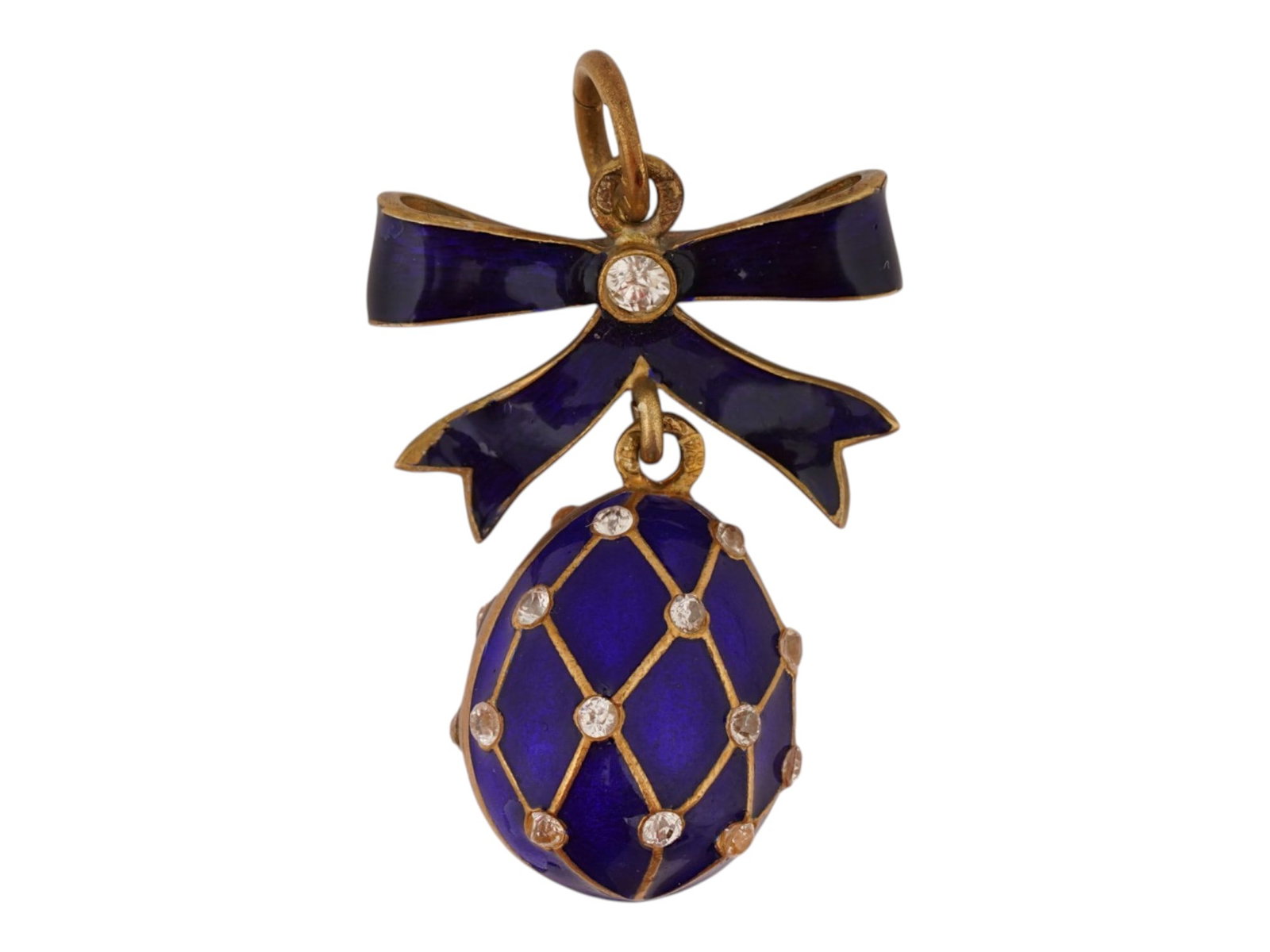 RUSSIAN SILVER ENAMEL EASTER EGG PENDANT W GEMSTONES: A Russian 84 Gilt Silver and enamel Easter egg pendant. The exterior of the egg is covered with polychrome Guilloche enamel in a cobalt blue shade. A gold wash interior. The egg is adorned with a latt