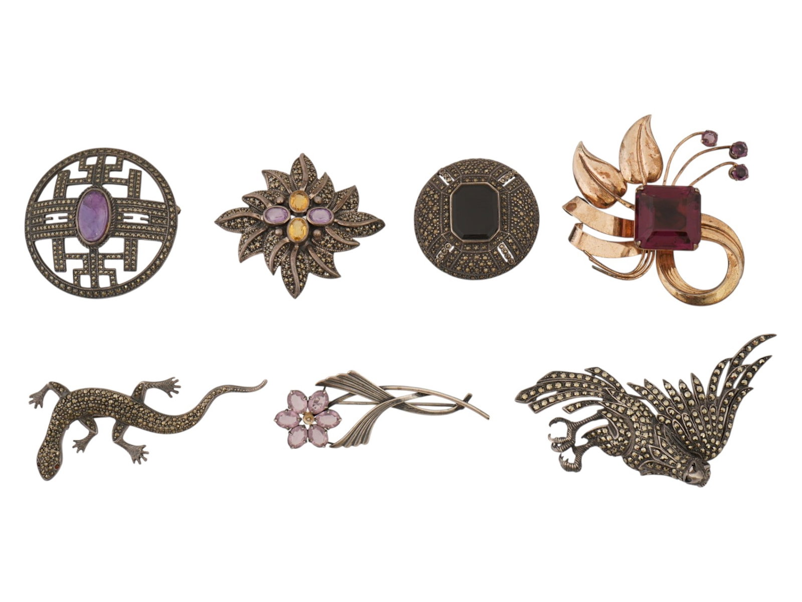 SEVEN SILVER BROOCHES SET WITH VARIOUS STONES: A group of seven silver brooches set with various stones. This lot contains silver and gilt silver brooches of approximately the same size, each with a different design reminiscent of Art Nouveau