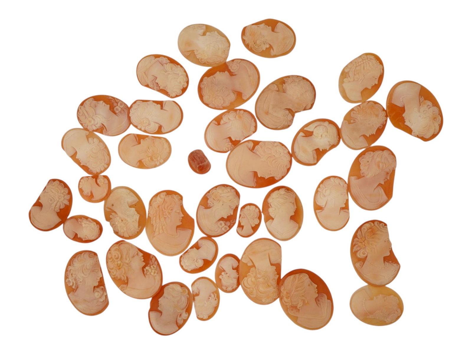 LOT OF DAMAGED FEMALE PORTRAIT CARVED SHELL CAMEOS: A lot of damaged hand carved conch shell cameos. A total of 36 items. Each piece depicts a female profile portrait rendered in high relief. Oval shape. Collectible Jewelry And Glyptic Art, Sculpture. 