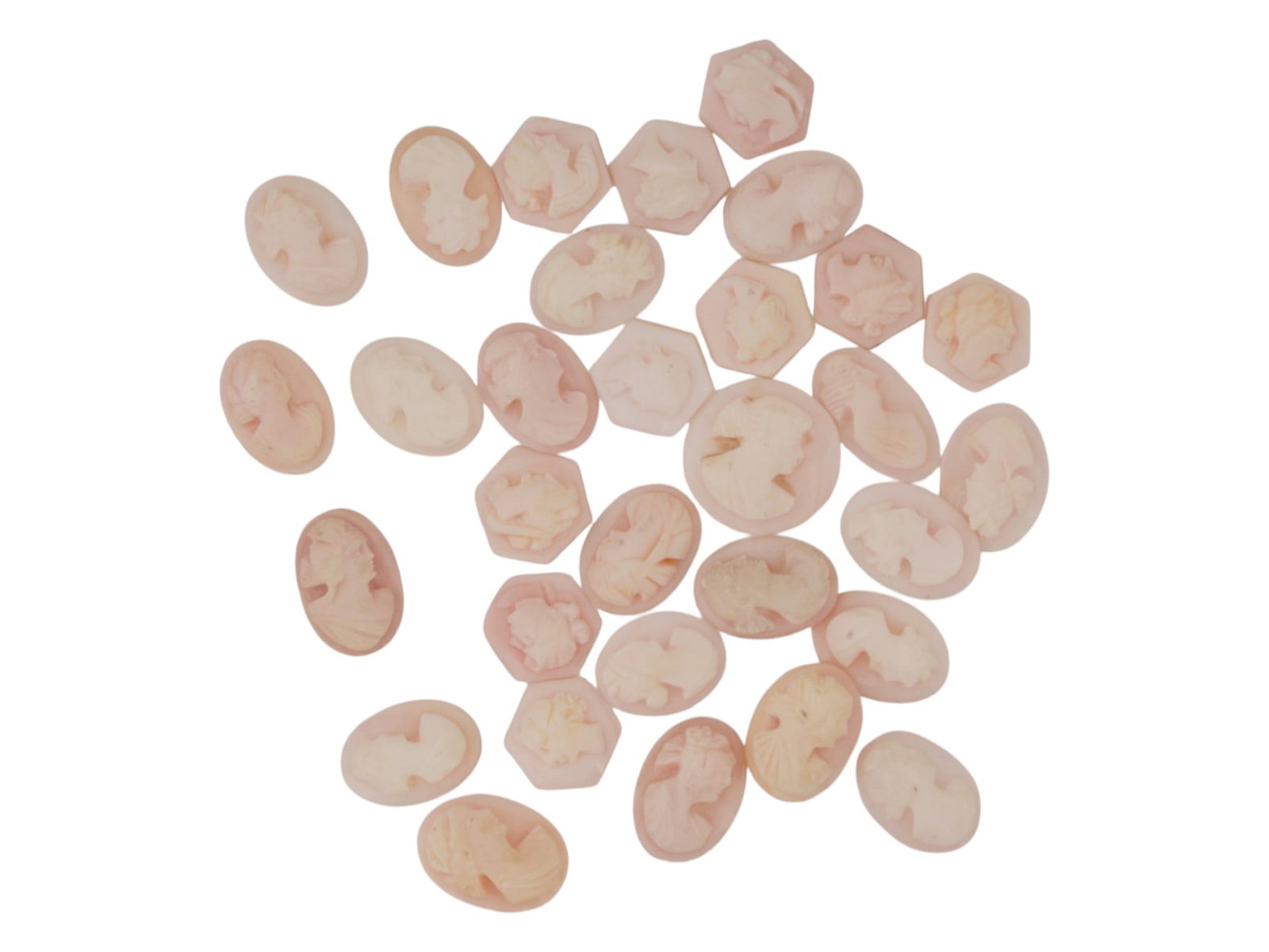 COLLECTION OF HAND CARVED CORAL CAMEO MEDALLIONS: A collection of vintage hand carved cameo medallions. A total of 31 items. Each piece is crafted from coral featuring a female portrait in the Victorian and Roman manners rendered in high relief. The 