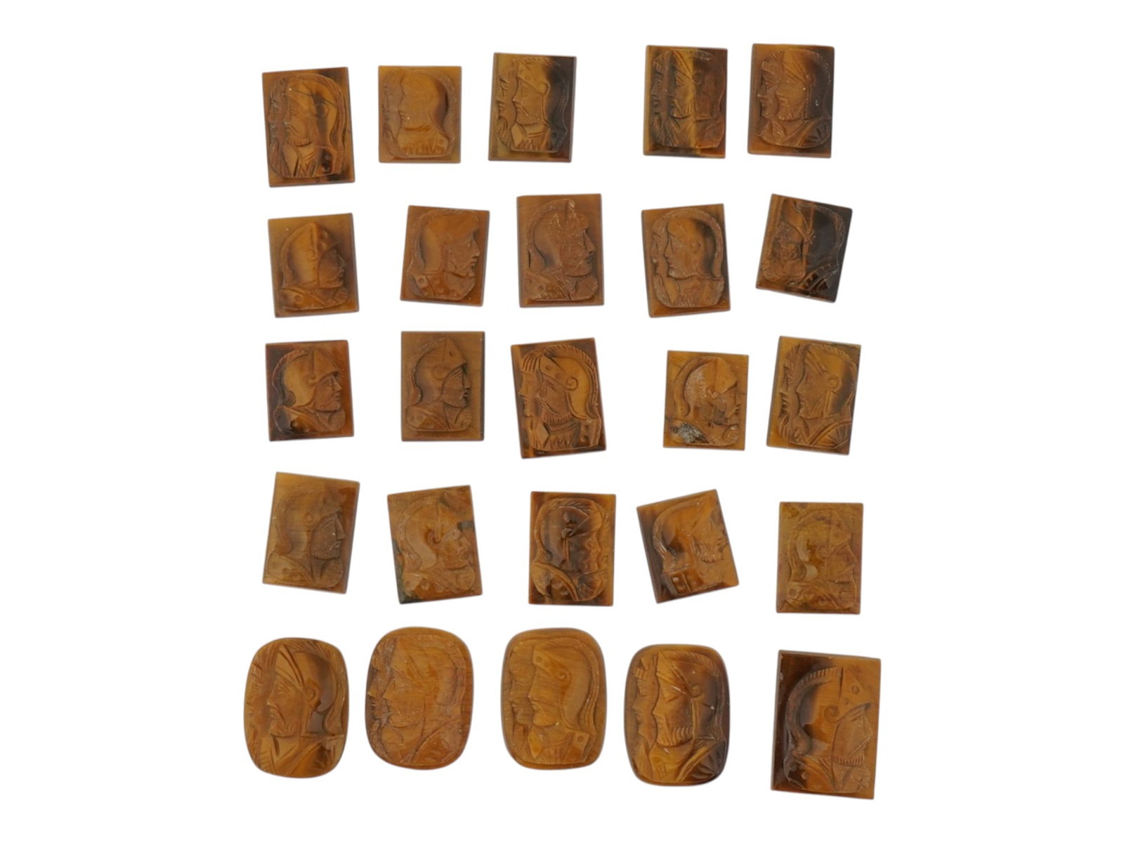 COLLECTION OF PORTRAIT CARVED TIGERS EYE CAMEOS: A collection of hand carved tigers eye cameos. A total of 25 items. Each piece features a double knight profile portrait rendered in high relief. Rectangular shape. Collectible Jewelry And Glyptic Art