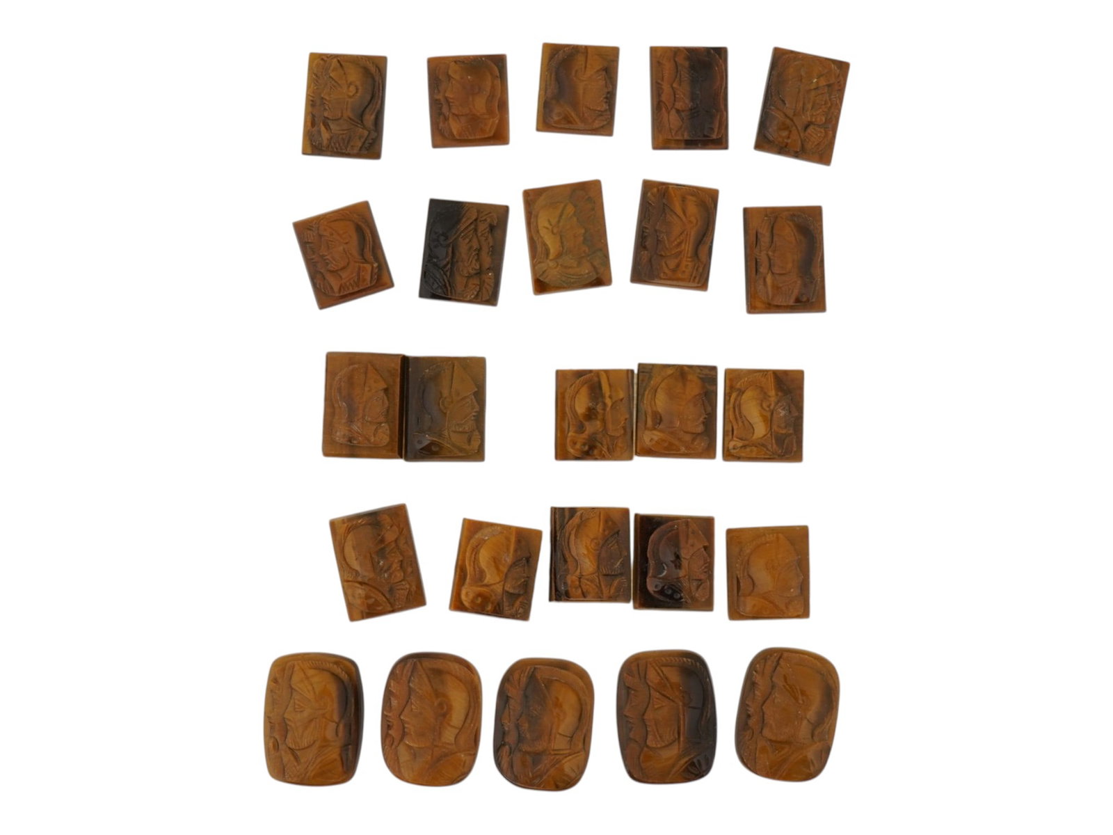 COLLECTION OF PORTRAIT CARVED TIGERS EYE CAMEOS: A collection of hand carved tigers eye cameos. A total of 25 items. Each piece features a double knight profile portrait rendered in high relief. Rectangular shape. Collectible Jewelry And Glyptic Art