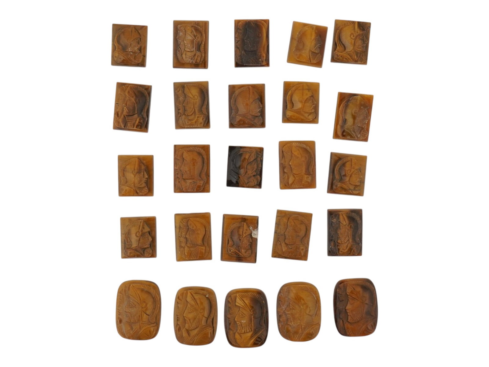 COLLECTION OF PORTRAIT HAND CARVED TIGERS EYE CAMEOS: A collection of twenty six hand carved tigers eye cameo medallions. The lot includes rectangular carvings depicting single and double profile armored warriors in the Roman manner. Made for rings, cuff