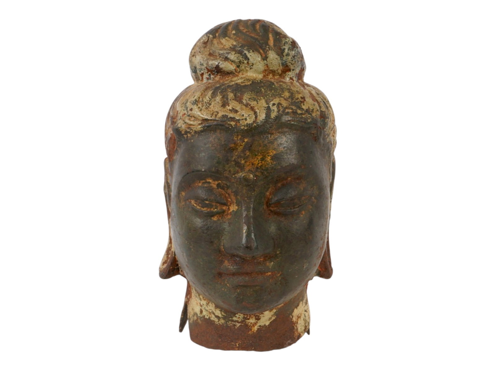 ANTIQUE SCULPTURAL FRAGMENT THE HEAD OF A BUDDHA: An antique metal sculptural fragment depicting the head of a Buddha. The piece features a serene expression with downcast eyes and a high chignon, elements characteristic of traditional Asian Buddhist