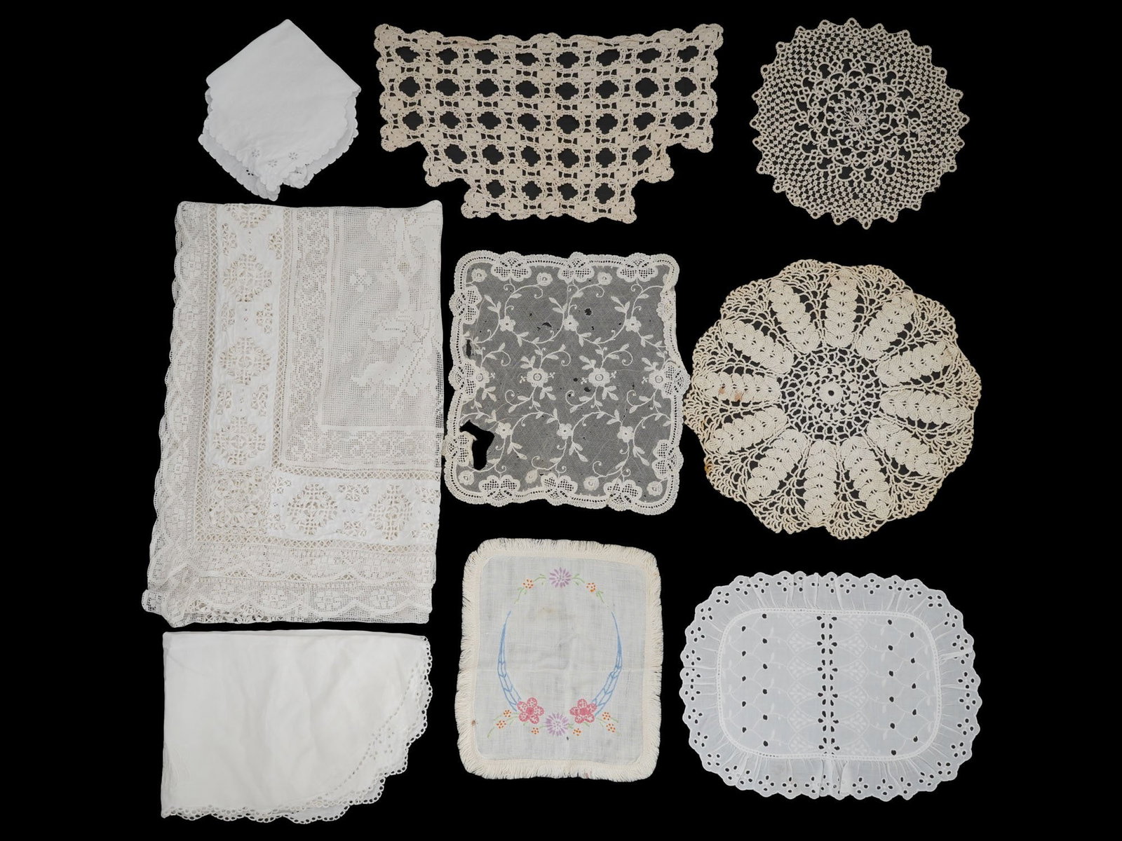 GROUP OF NINE VINTAGE HAND STITCHED LINEN NAPKINS: A group of nine vintage hand stitched linen napkins. This set includes an array of styles, from elegantly embroidered floral patterns to intricate lace work. The assortment highlights different textur