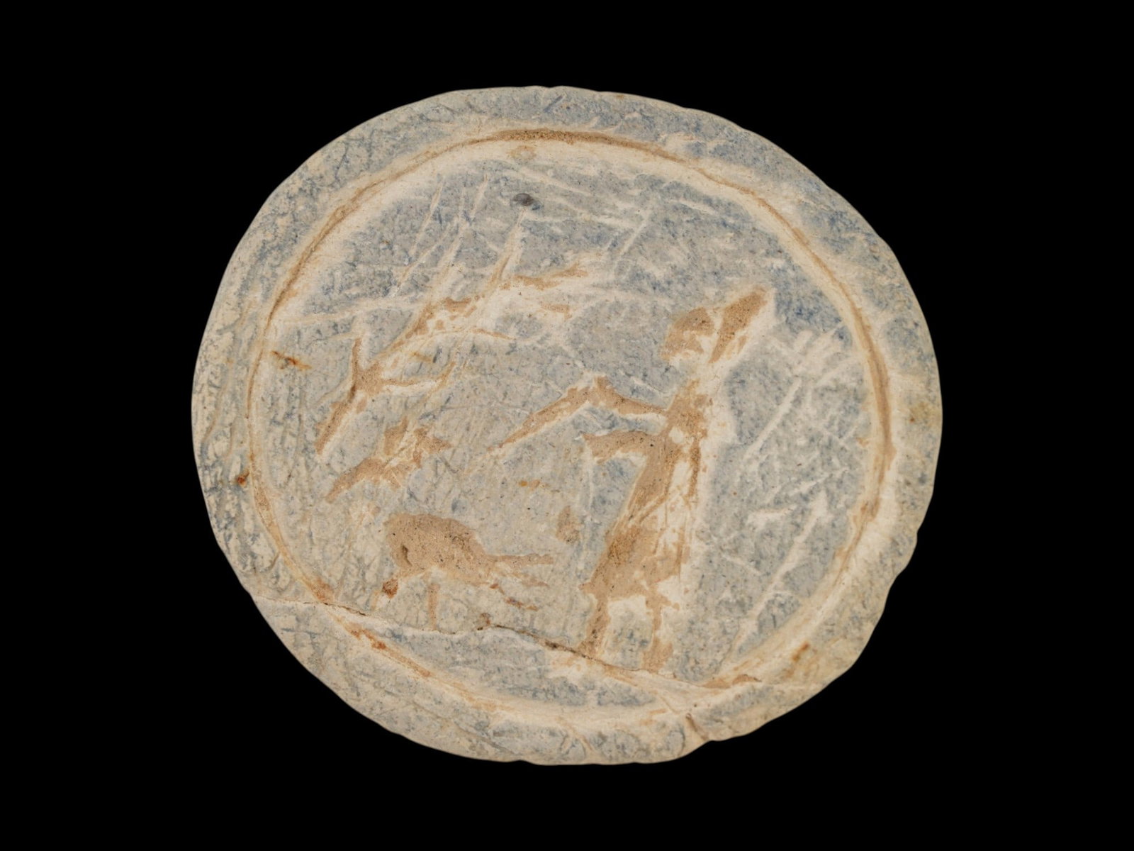 ANCIENT HOLY LAND STONE PENDANT WITH A RITUAL IMAGE: An ancient Holy Land stone pendant dating to the 1st millennium BC and is engraved with a ritual image depicting a standing male figure in the field. Such pendants were typically worn as personal amul