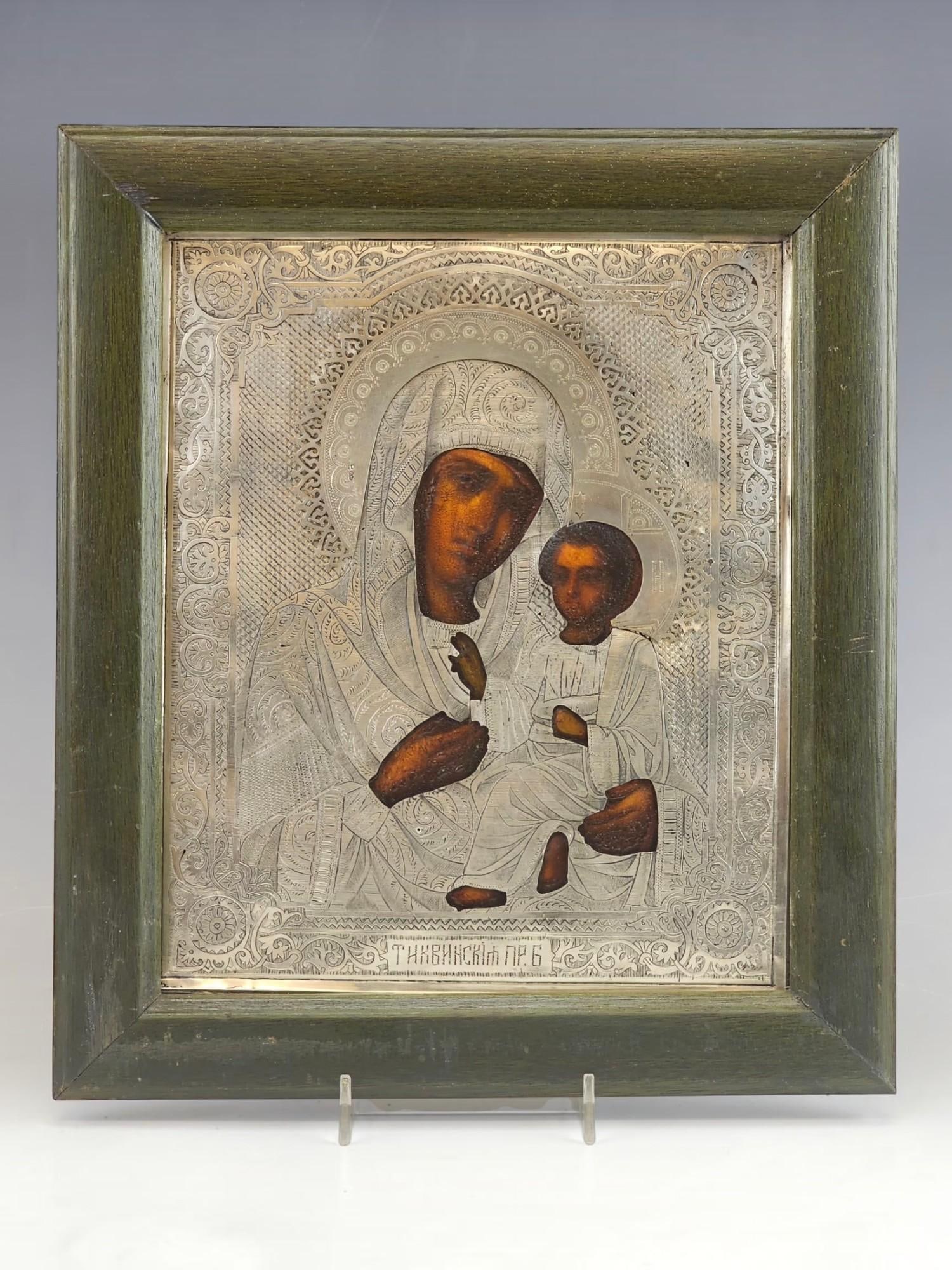 RUSSIAN ORTHODOX SILVER ICON TIKHVIN MOTHER OF GOD: A Russian Orthodox icon depicting the Tikhvin Mother of God, mounted in a silver oklad. The silver cover is hallmarked with the 84 silver standard proof and makers marks. Dating to the 19th century. R