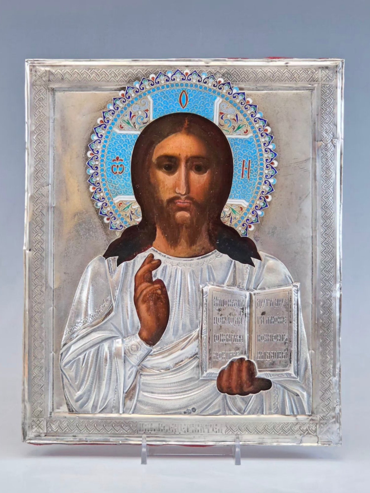 ANTIQUE 19TH C RUSSIAN ICON LORD ALMIGHTY IN SILVER RIZA: An antique Russian Orthodox icon representing Jesus in the Christ Pantocrator iconography, known in the Western Christianity as Christ in Majesty. Dated 19th century. Mixed media painting: egg tempera