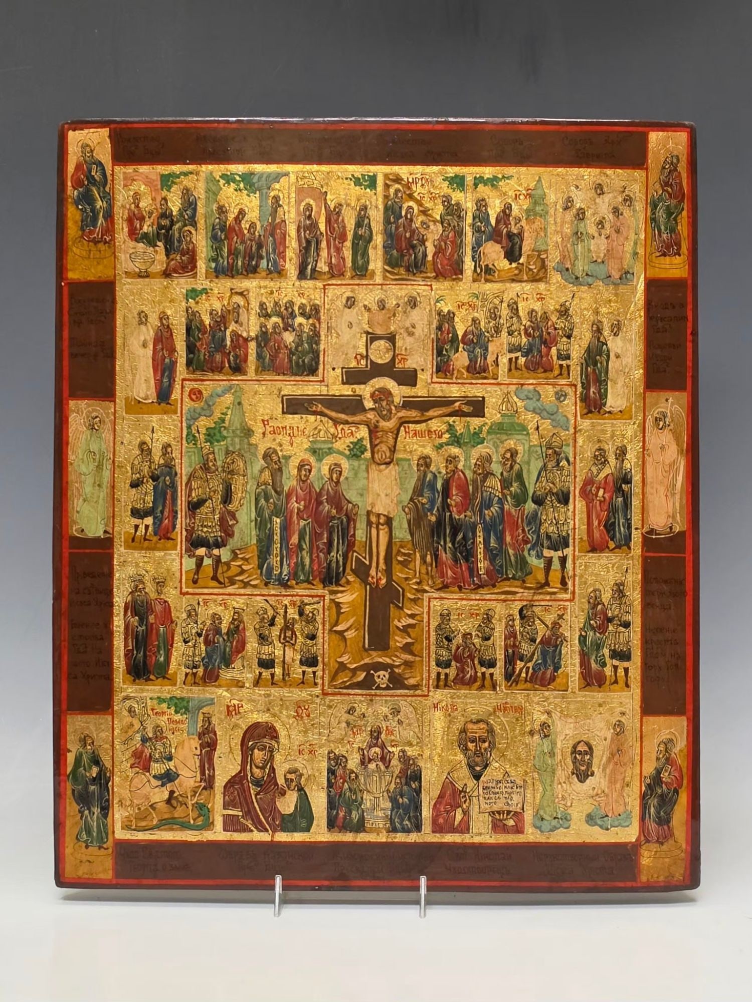 ANTIQUE RUSSIAN ICON CRUCIFIXION CHRIST PASSION CYCLE: A large Russian Orthodox icon created in egg tempera gold leaf on a gessoed wood panel. The icon features a central depiction of the Crucifixion of Christ surrounded by detailed scenes from the Passio