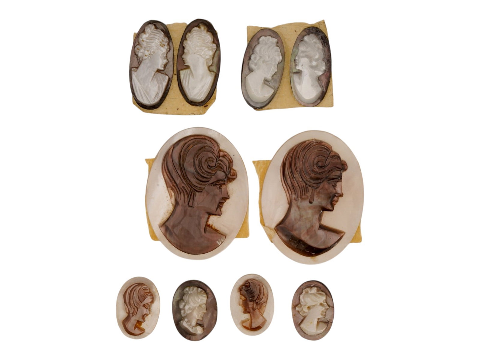 COLLECTION OF HAND CARVED SHELL CAMEO MEDALLIONS: A collection of vintage hand carved cameo medallions. A total of 10 items. Each piece is crafted from conch shell featuring a female portrait in the Victorian manner rendered in high relief. The cameo