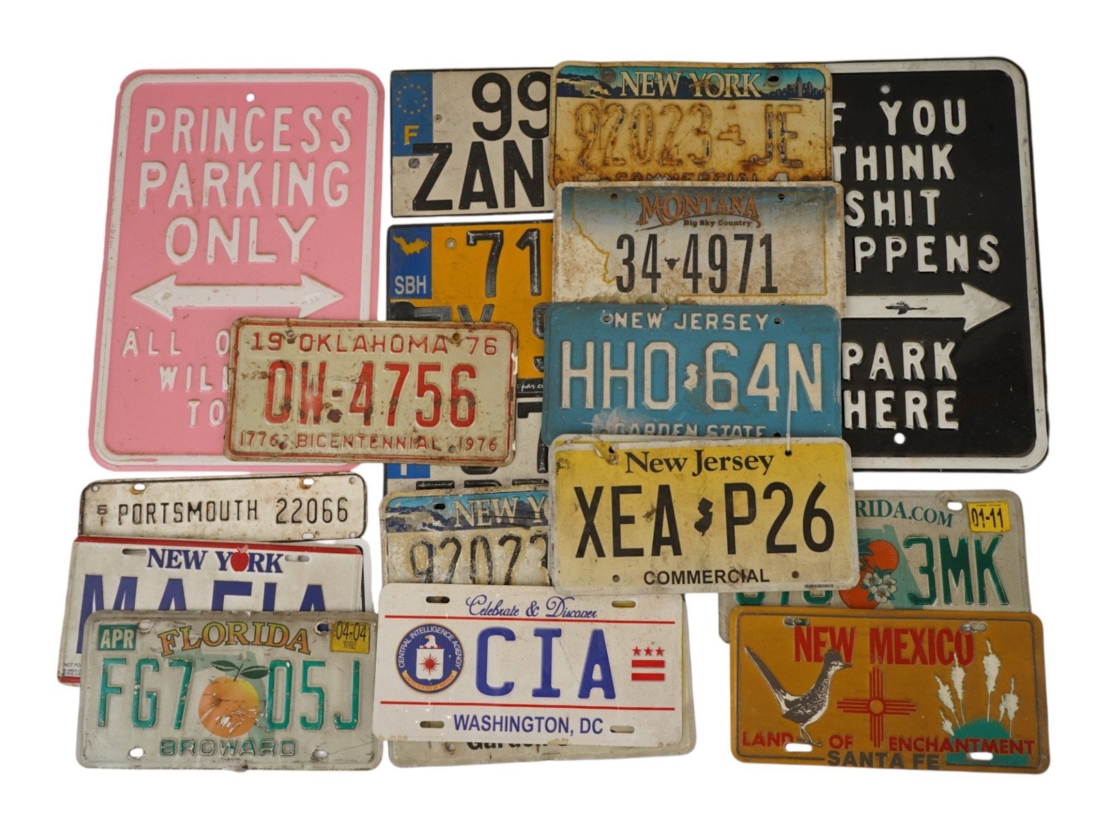 AMERICAN LICENSE PLATES AND SOUVENIR METAL ROAD SIGNS: A collection of vintage American vehicle registration plates and souvenir metal road signs. A total of 20 items. Pieces from various U.S. states, with markings and inspection stickers. Car Collectible