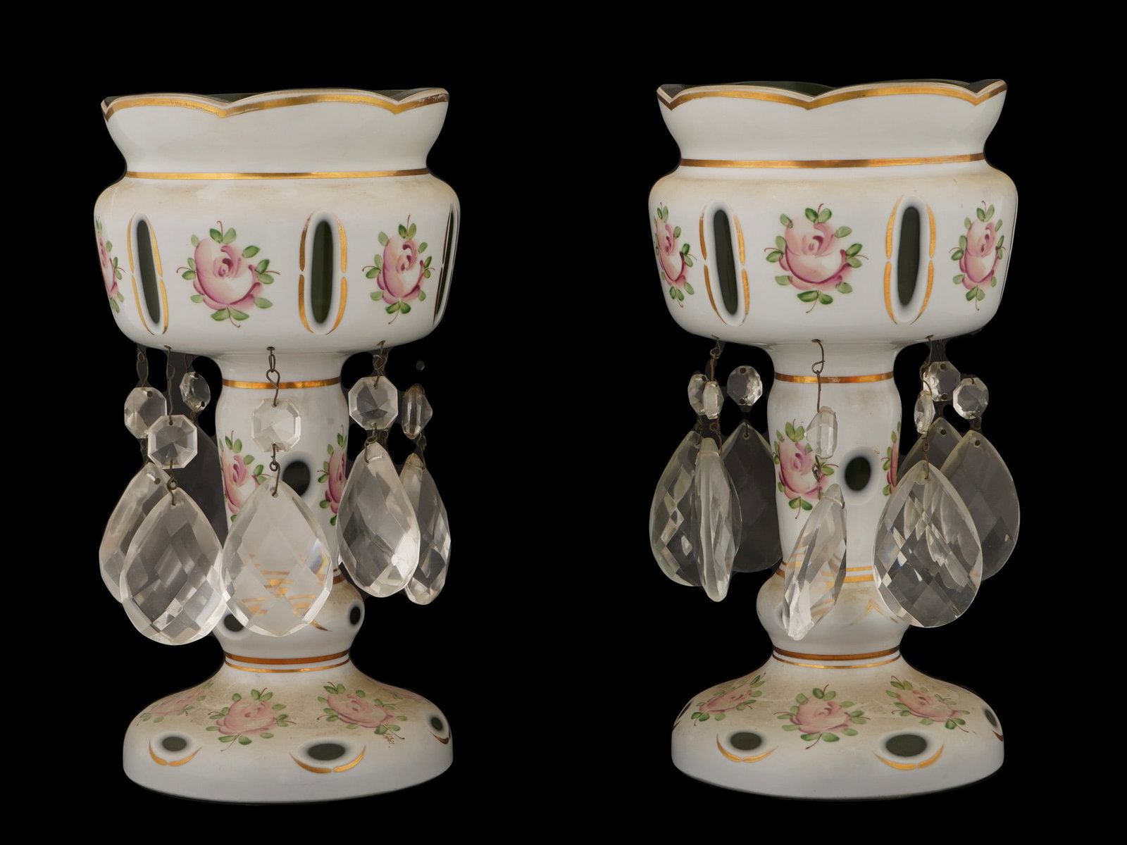 PAIR OF ANTIQUE CZECH CASED GLASS MANTEL LUSTERS: A pair of antique Czech Bohemian glass mantel lusters, white glass cut to green, hand-painted with pink rose clusters and gilt accents. The opaque white glass bodies feature green cutaway panels and a