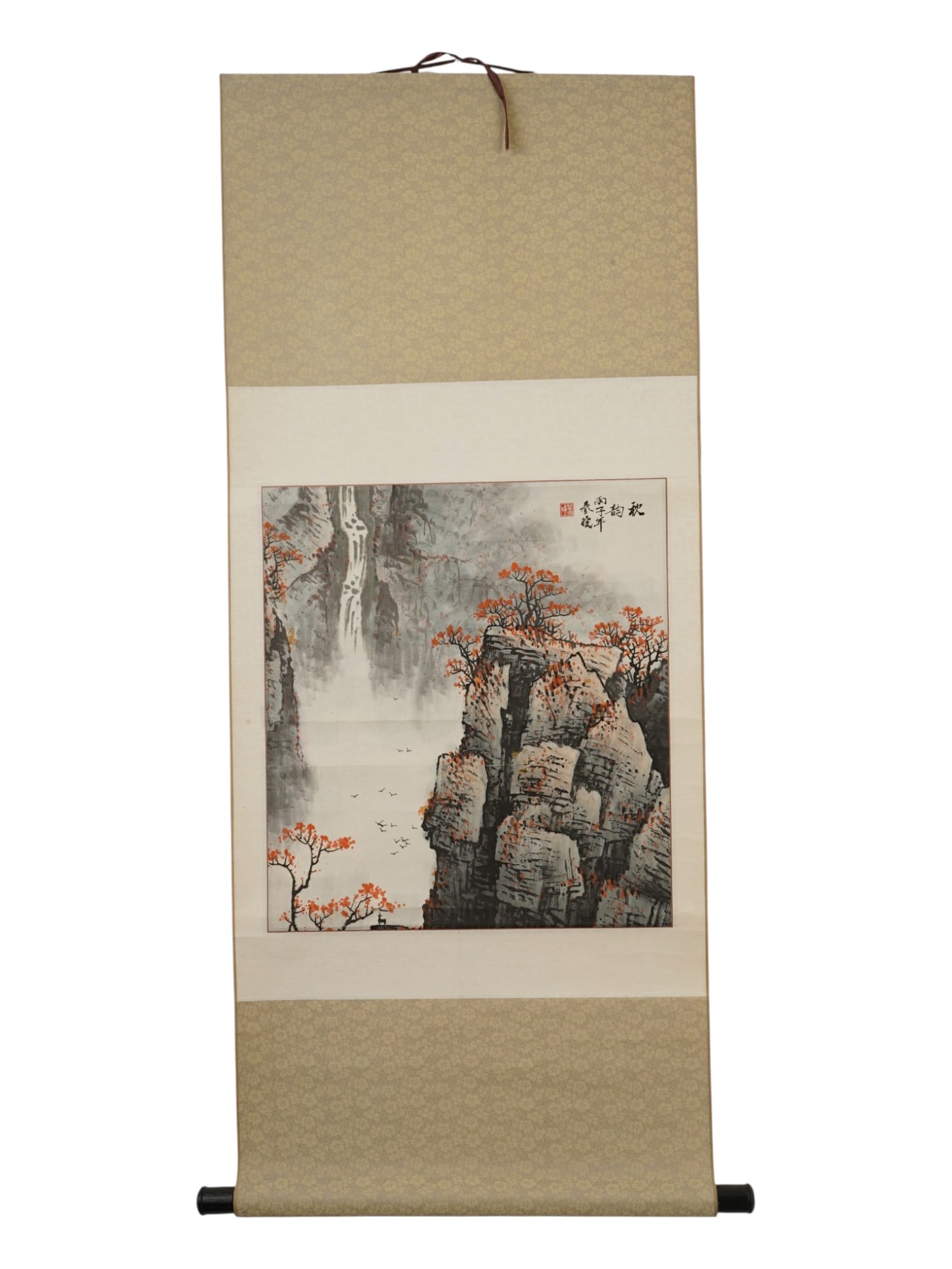 CHINESE LANDSCAPE WATERCOLOR AND INK PAINTING: A Chinese landscape watercolor and ink painting on paper. The painting depicts an autumn landscape with a waterfall, rocky mountains and trees with red foliage. Brocade border and wooden roller end.