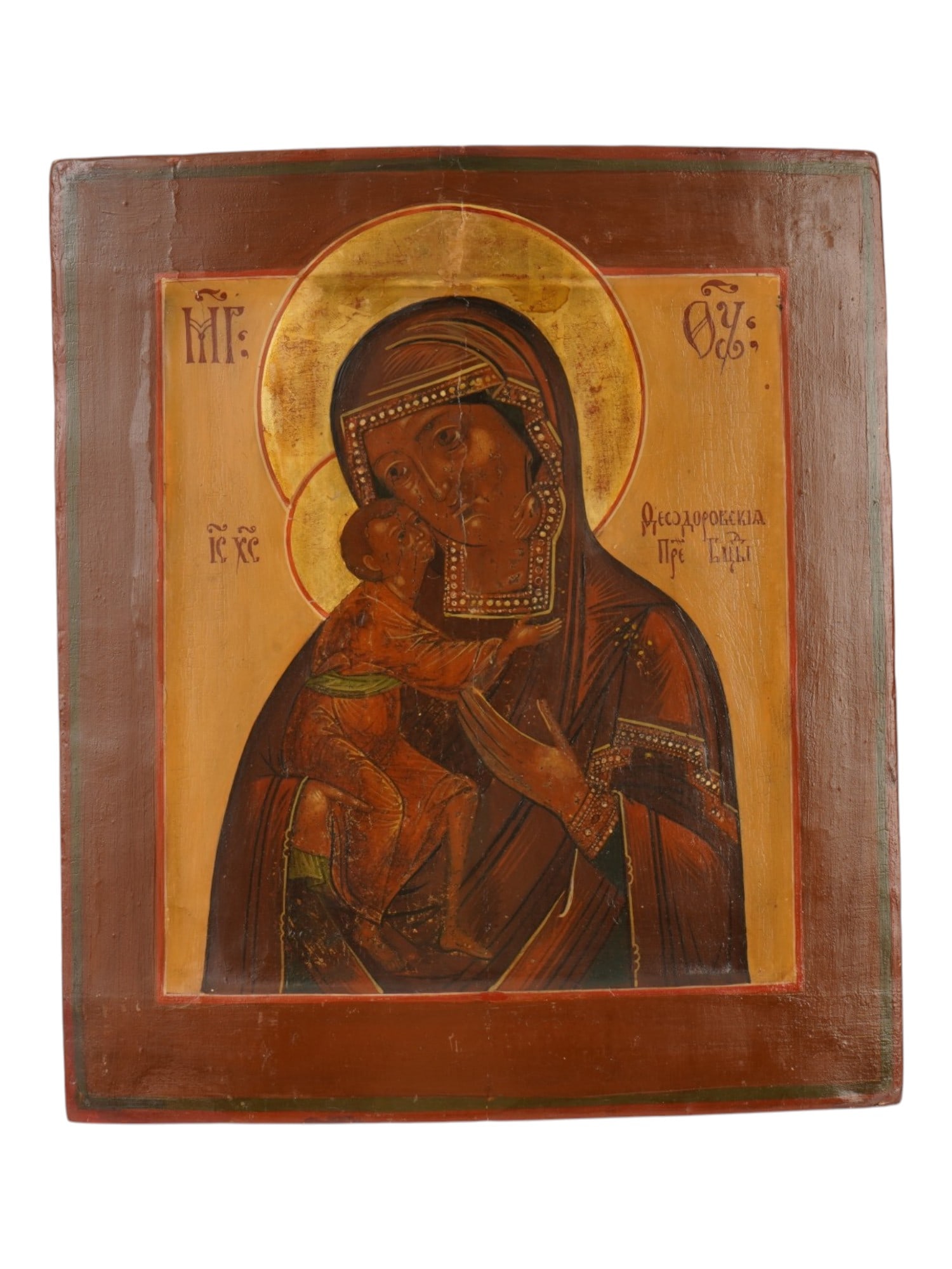 ANTIQUE RUSSIAN ORTHODOX ICON FEODOROVSKAYA MOTHER GOD: An antique Russian Orthodox icon of the Feodorovskaya Mother of God. The Virgin tenderly holds the Christ Child, who presses his cheek to hers in an intimate gesture of affection. Inscribed in Russian