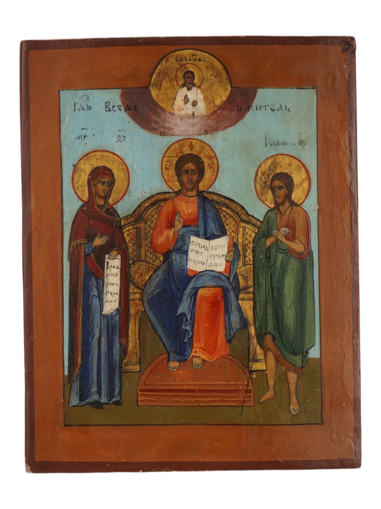 ANTIQUE RUSSIAN ORTHODOX ICON OF THE DEESIS: An antique Russian Orthodox icon of the Deesis, painted in a traditional provincial folk style. Christ Pantocrator sits enthroned at the center, flanked by the Virgin Mary and Saint John the Baptist i