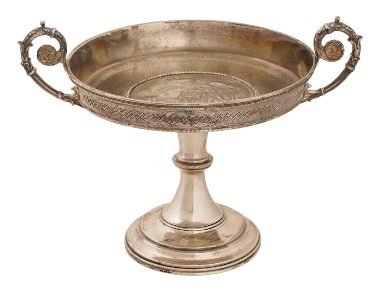 RUSSIAN 84 SILVER FOOTED CANDY BOWL W IMPERIAL MEDAL: A Russian Silver footed candy bowl. The deep bowl sits on a tall, conical stem with a stepped, round base. Two massive volute handles are positioned on either side, decorated with a raised floral moti