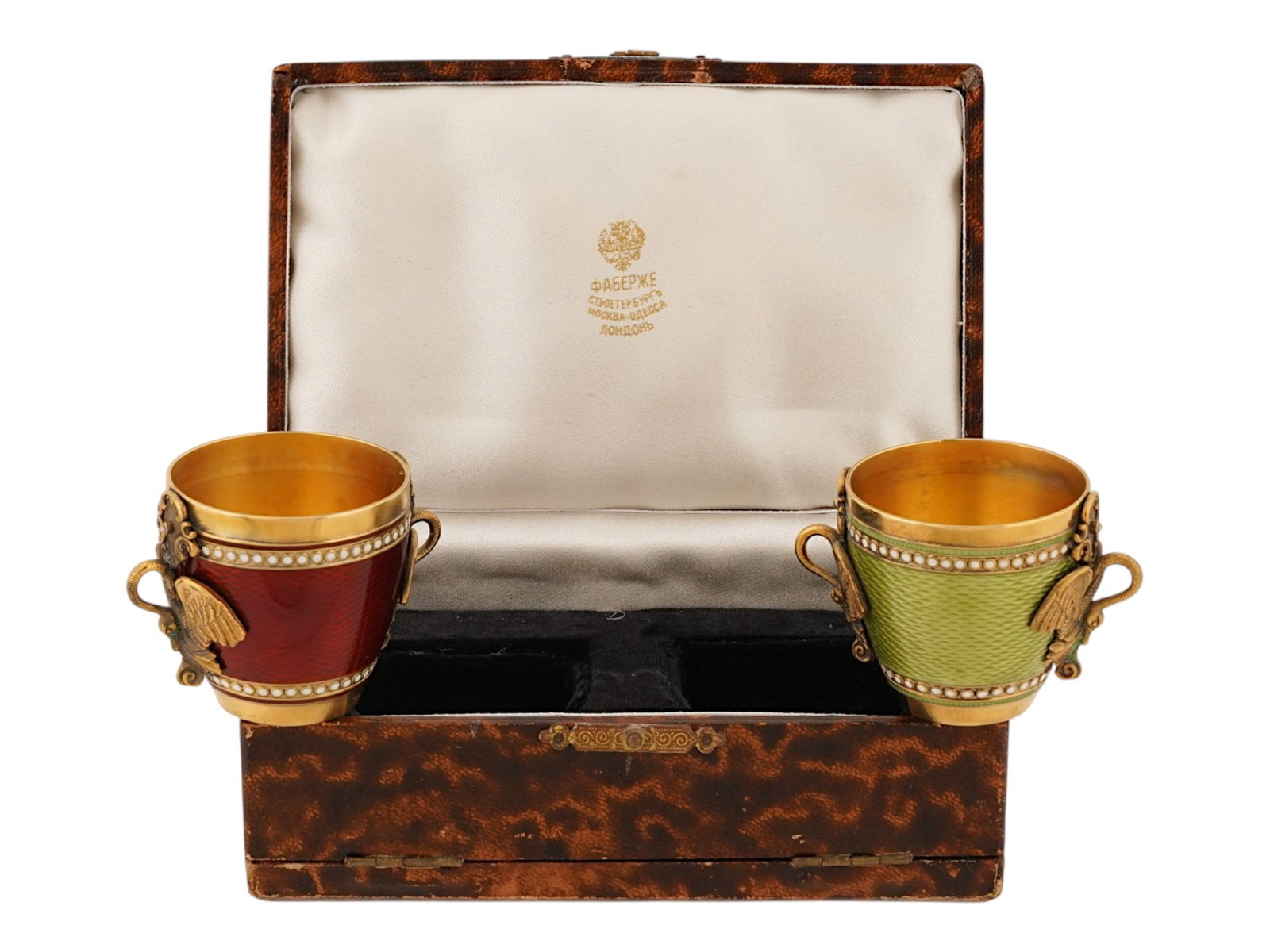 PAIR OF RUSSIAN GILT SILVER GUILLOCHE ENAMEL SHOT CUPS: A pair of matching Russian gilt silver shot cups. Guilloche enamel body, one in red, the other in green color. Swan-shaped side handles embellished with gemstones. Hallmark of 84 silver standard and