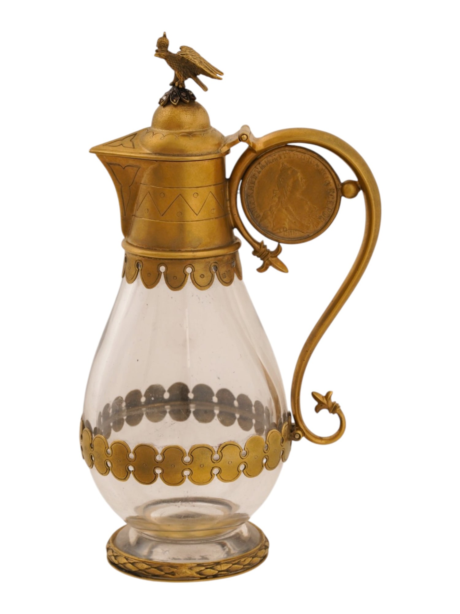 RUSSIAN GILT SILVER GLASS DIAMOND COIN PITCHER: A Russian gilt silver and clear glass pitcher. Shield and laurel wreath decor. The hinged lid is topped by an Imperial Eagle embellished with diamonds. The curved handle is set with a 1769 Five Ruble 