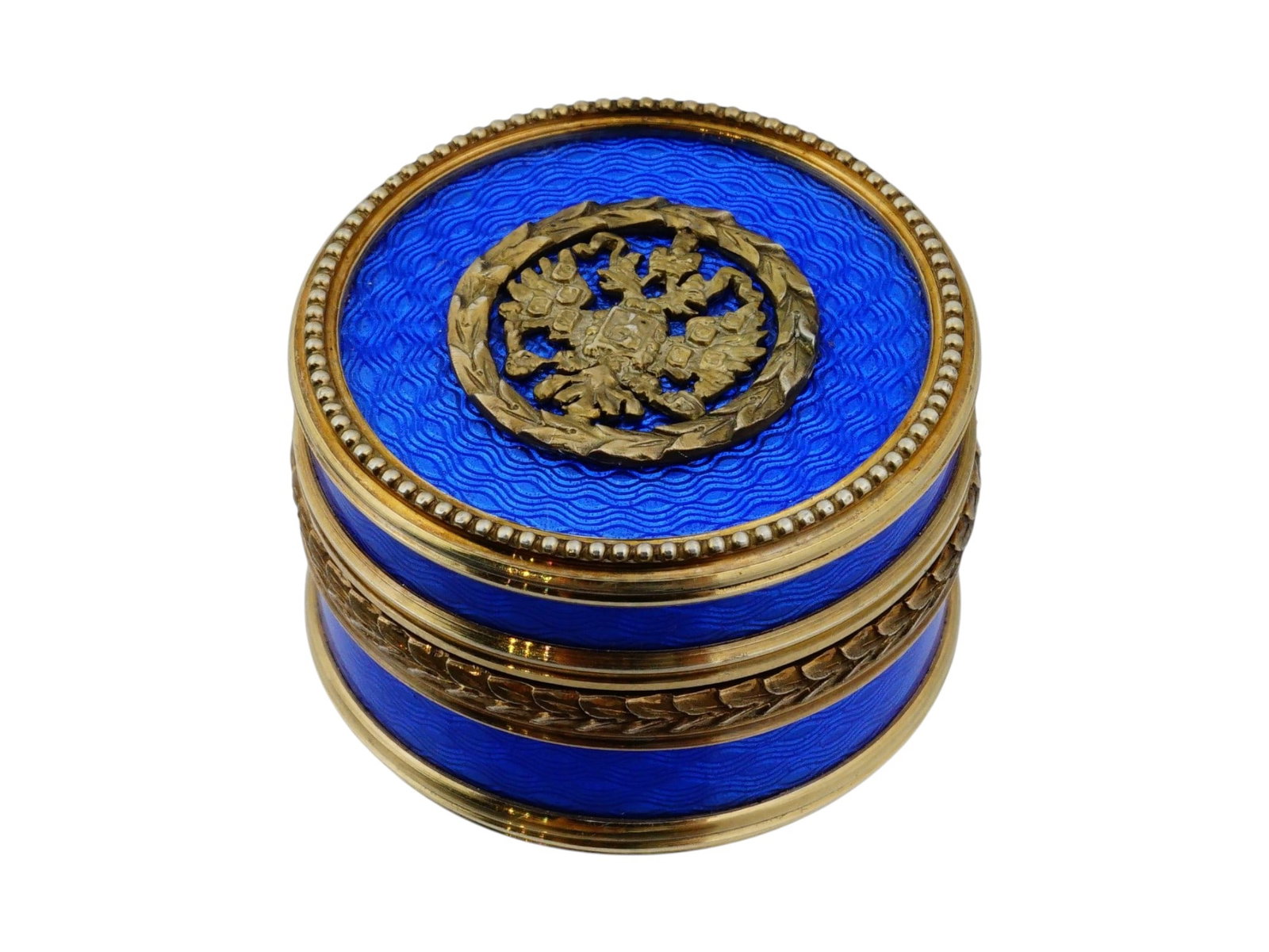 RUSSIAN GILT SILVER AND GUILLOCHE ENAMEL PILL BOX: A Russian gilt silver pill or snuff box. Round piece with blue guilloche enamel surface. The lid is garnished with a relief Imperial Eagle. Hallmark of 84 silver standard and makers mark on the inside