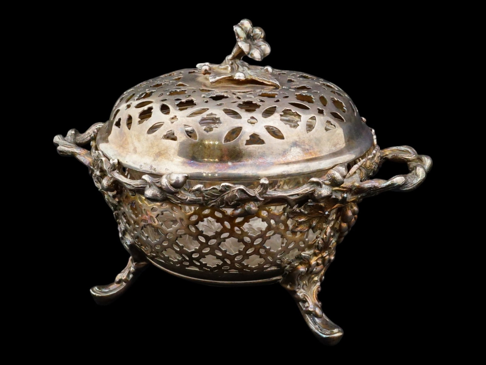 ANTIQUE CHRISTOFLE FRENCH SILVER PLATED SUGAR BOWL: An antique late 19th-century silver-plated lidded sugar bowl, attributed to Christofle. Tripod piece with side handles. Elaborate pierced and sculpted floral decoration. The item comes with a carved g