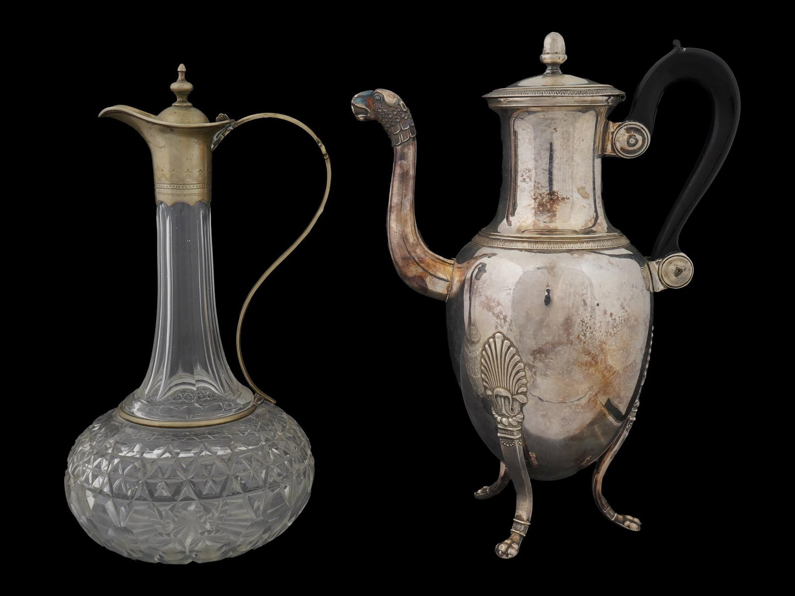 VINTAGE CRYSTAL PITCHER AND SILVER PLATE TEA POT: A lot of two vintage tableware pieces. First. A cut glass pitcher or wine decanter with elongated neck. Brass handle, spout, and hinged lid bear engraved ornaments. Unmarked. Second. A silver-plated t