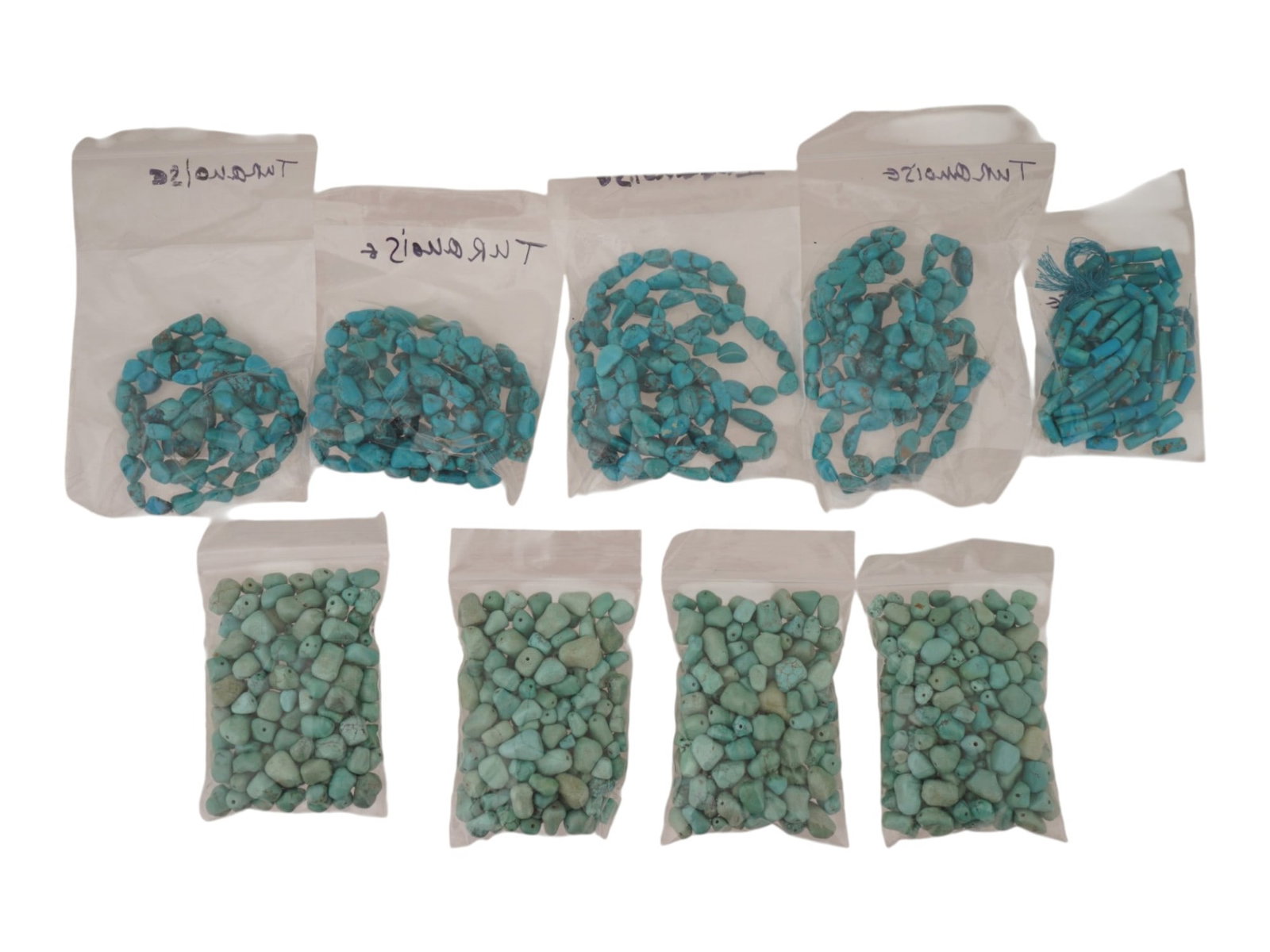 LARGE COLLECTION OF TURQUOISE BEADS: A large collection of turquoise beads in various shapes ready to be crafted into a necklace. The beads exhibit the vibrant blue and green hues typical of turquoise, along with unique natural veining p