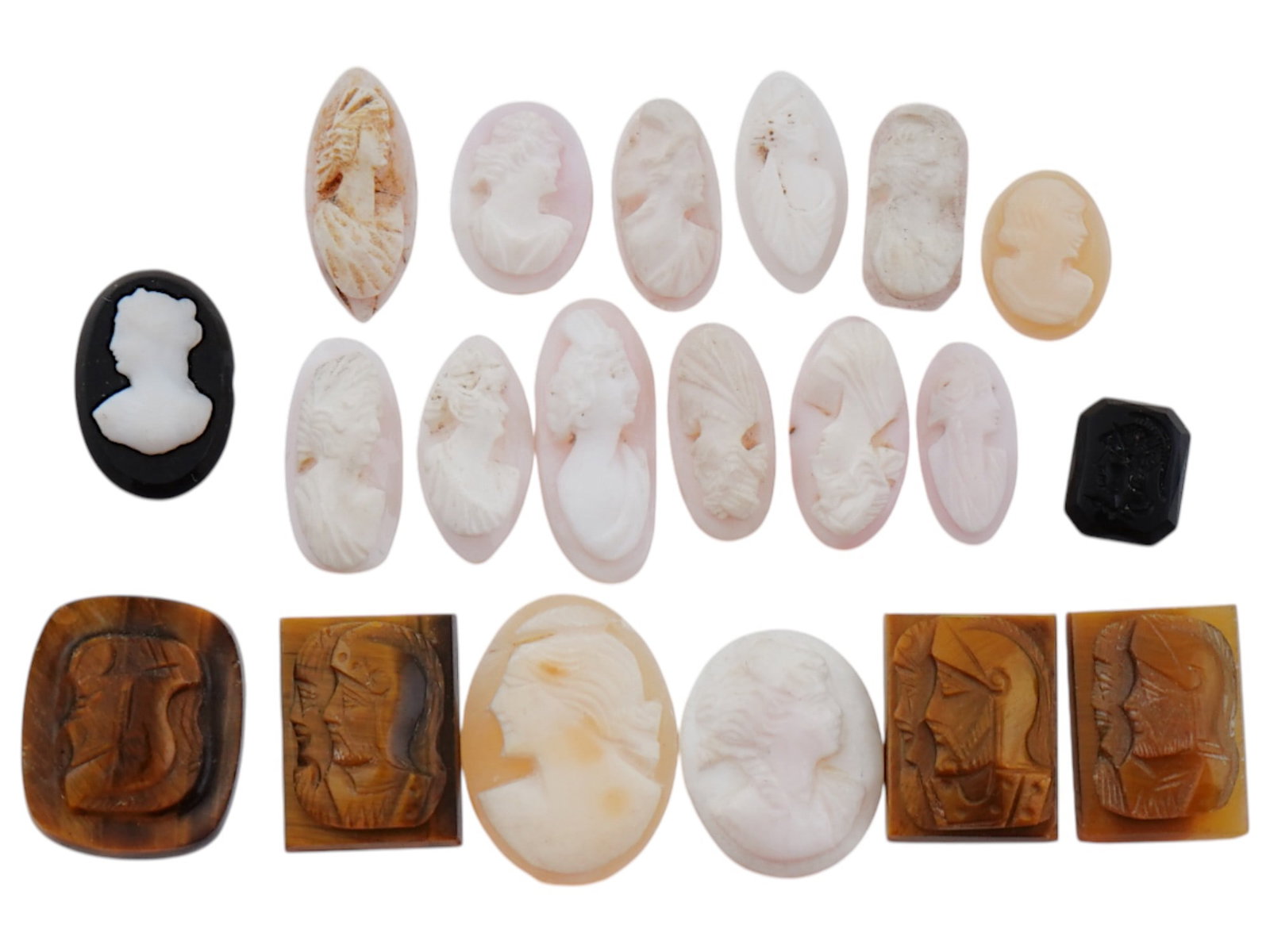 COLLECTION OF ANTIQUE HAND CARVED CAMEOS: A large collection of antique Neoclassical hand carved cameos. Some pieces feature double portraits of warriors, and some feature female portraits. Oval and rectangular shaped. Dating back to the late