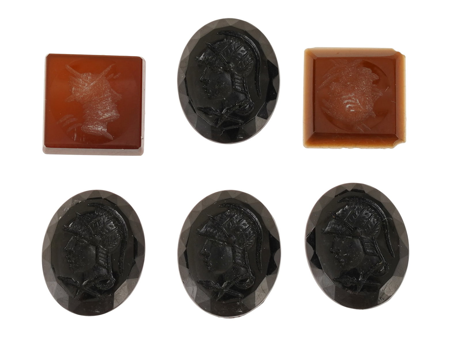 COLLECTION OF WARRIOR PROFILE PORTRAIT GLASS CAMEOS: A collection of six vintage glass cameo medallions in various sizes and shapes. The collection includes four oval shaped specimens in a dark, opaque black hue and two square shaped examples in a trans