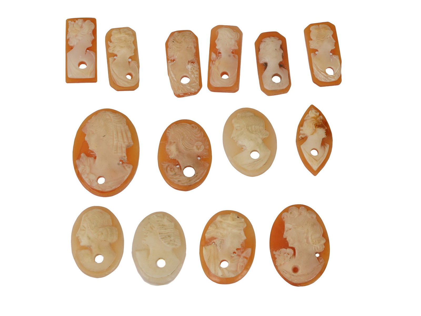 COLLECTION OF CARVED FEMALE PORTRAIT SHELL CAMEOS: A collection of hand carved shell cameos. A total of 14 items. Each piece depicts a female profile portrait rendered in high relief in the Victorian and Roman manners. Each cameo is fashioned in disti