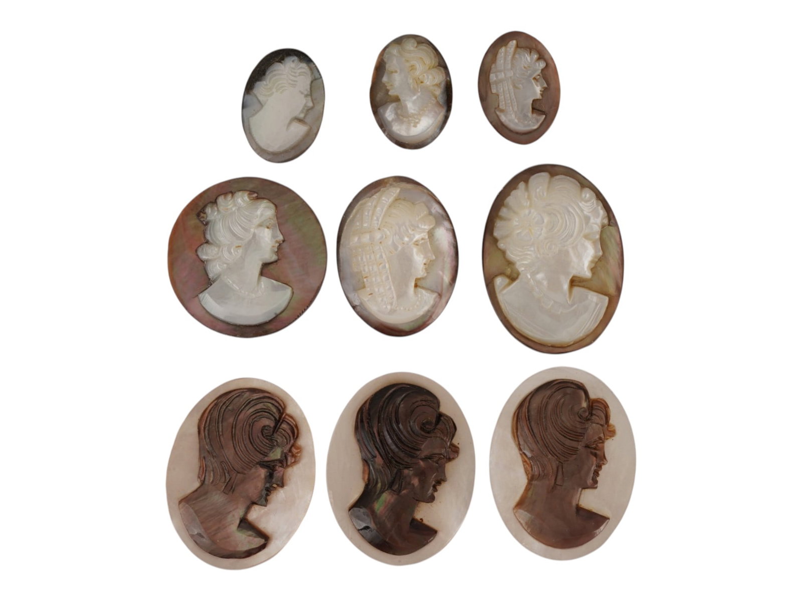 COLLECTION OF FEMALE PORTRAIT CARVED SHELL CAMEOS: A collection of hand carved shell cameos. A total of 9 items. Each piece features female profile portraits rendered in high relief. Elongated oval and round shape. Collectible Jewelry And Glyptic Art,