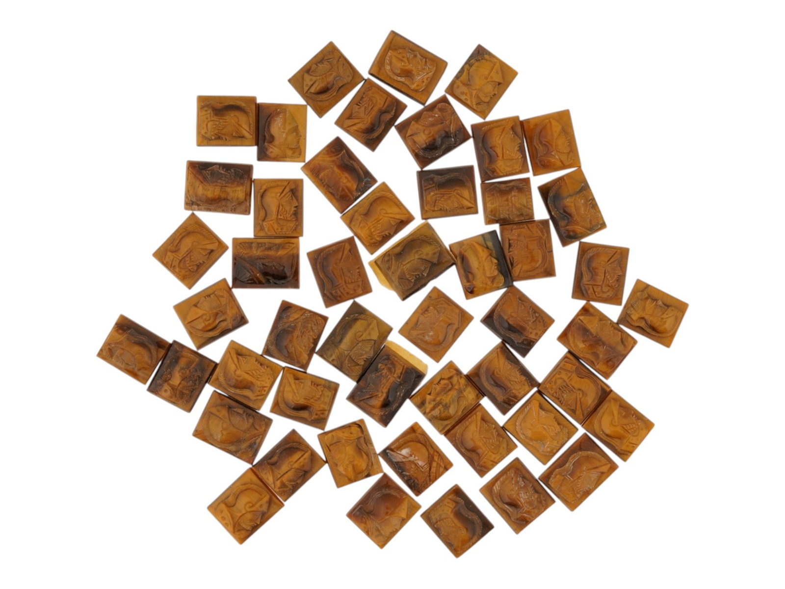 COLLECTION OF PORTRAIT CARVED TIGERS EYE CAMEOS: A collection of hand carved tigers eye cameos. A total of 50 items. Each piece features a double knight profile portrait rendered in high relief. Rectangular shape. Collectible Jewelry And Glyptic Art