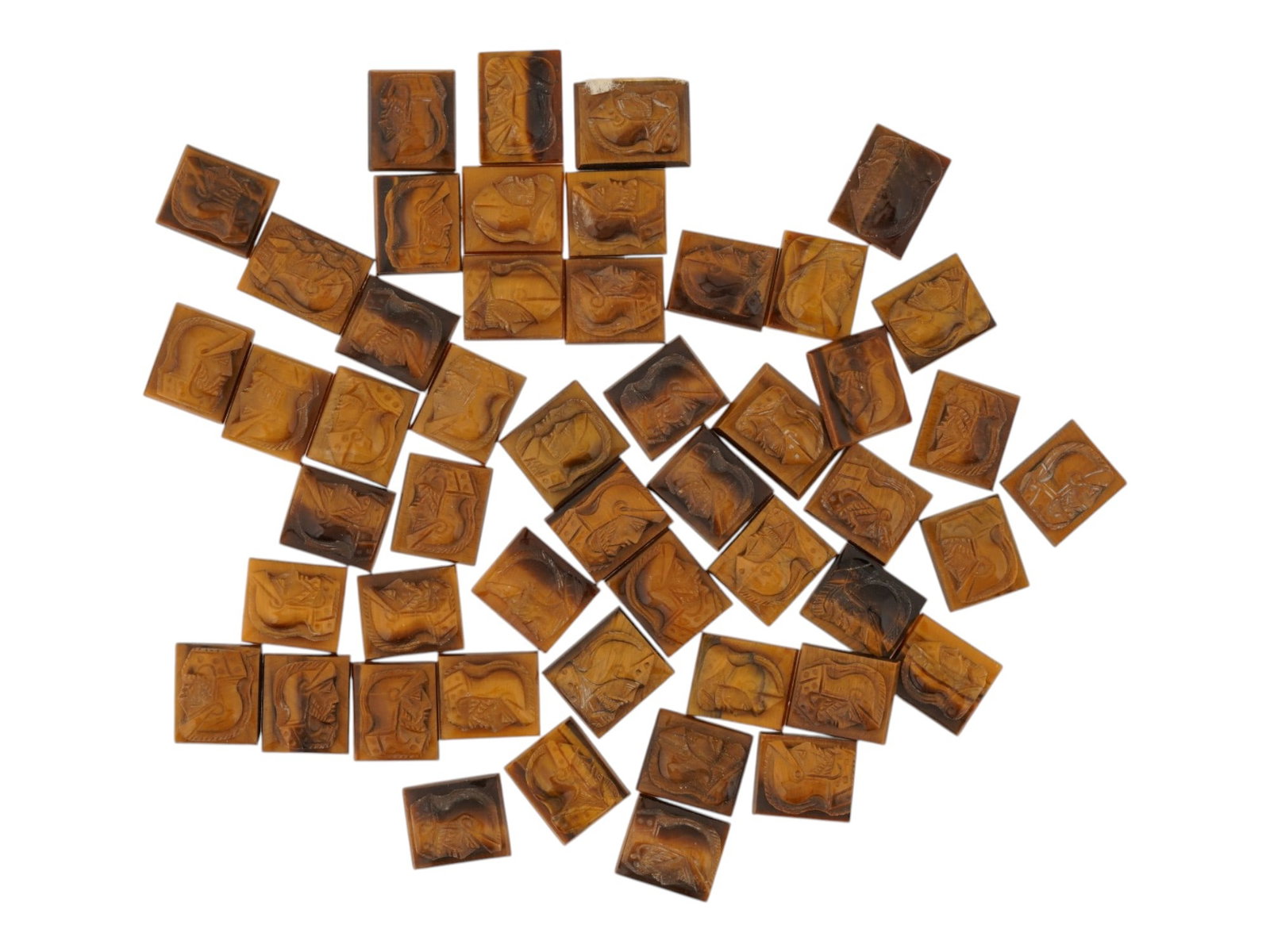 COLLECTION OF PORTRAIT CARVED TIGERS EYE CAMEOS: A collection of hand carved tigers eye cameos. A total of 50 items. Each piece features a double knight profile portrait rendered in high relief. Rectangular shape. Collectible Jewelry And Glyptic Art