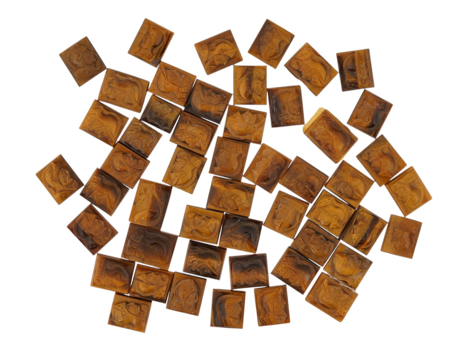 COLLECTION OF PORTRAIT CARVED TIGERS EYE CAMEOS: A collection of hand carved tigers eye cameos. A total of 50 items. Each piece features a double knight profile portrait rendered in high relief. Rectangular shape. Collectible Jewelry And Glyptic Art