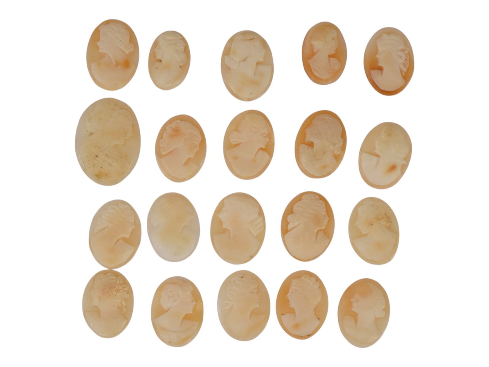 COLLECTION OF 20 UNMOUNTED VINTAGE SHELL CAMEOS: A collection of twenty unmounted vintage shell cameos, hand-carved with classical female profiles in traditional glyptic style. The group displays varied relief depths, distinctive hairstyles, floral 